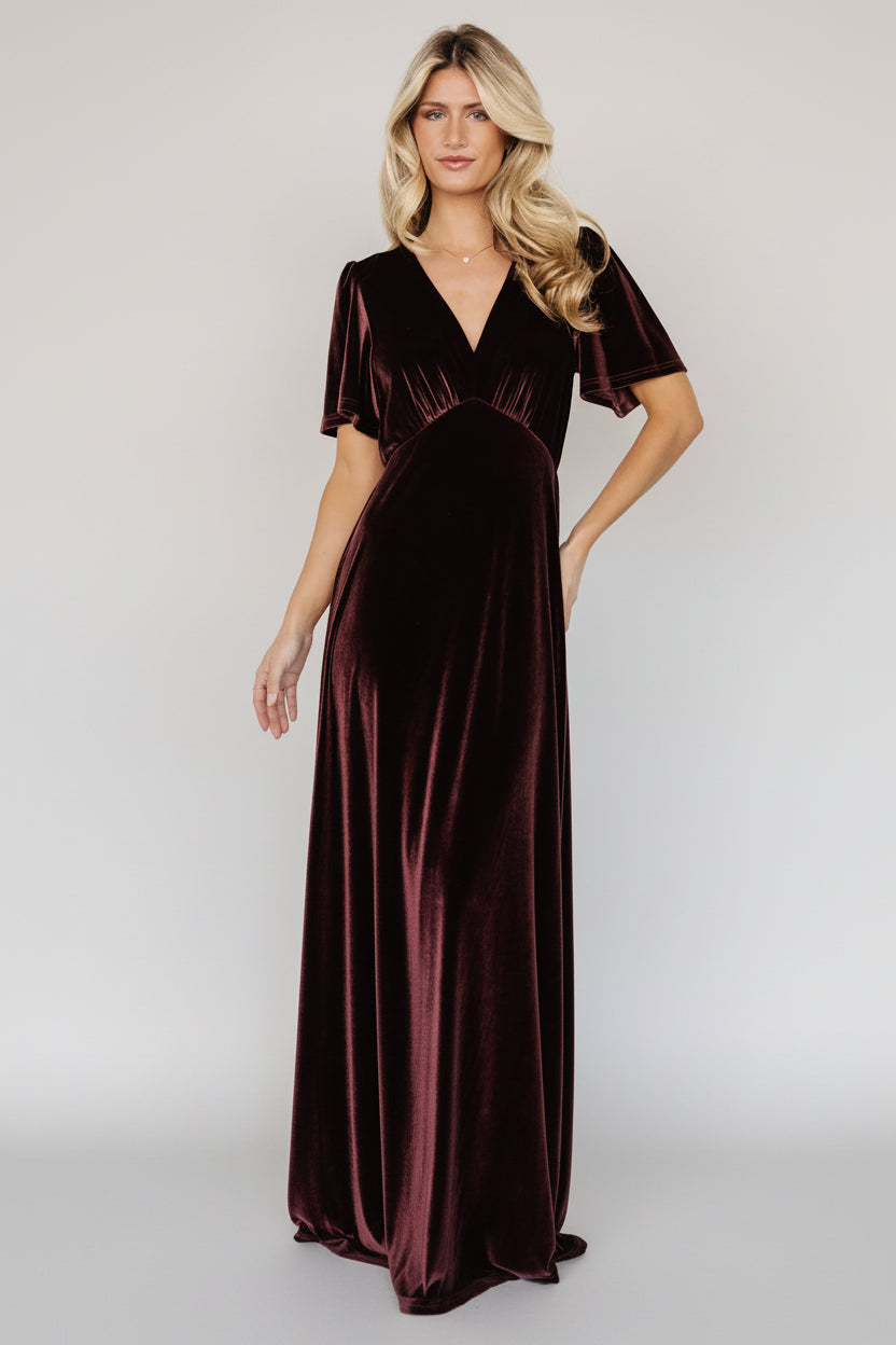 Back angle of the Vivian Velvet Maxi Dress in Clove showing the keyhole closure, gentle gathers at the waist, and the gown-length skirt’s movement.