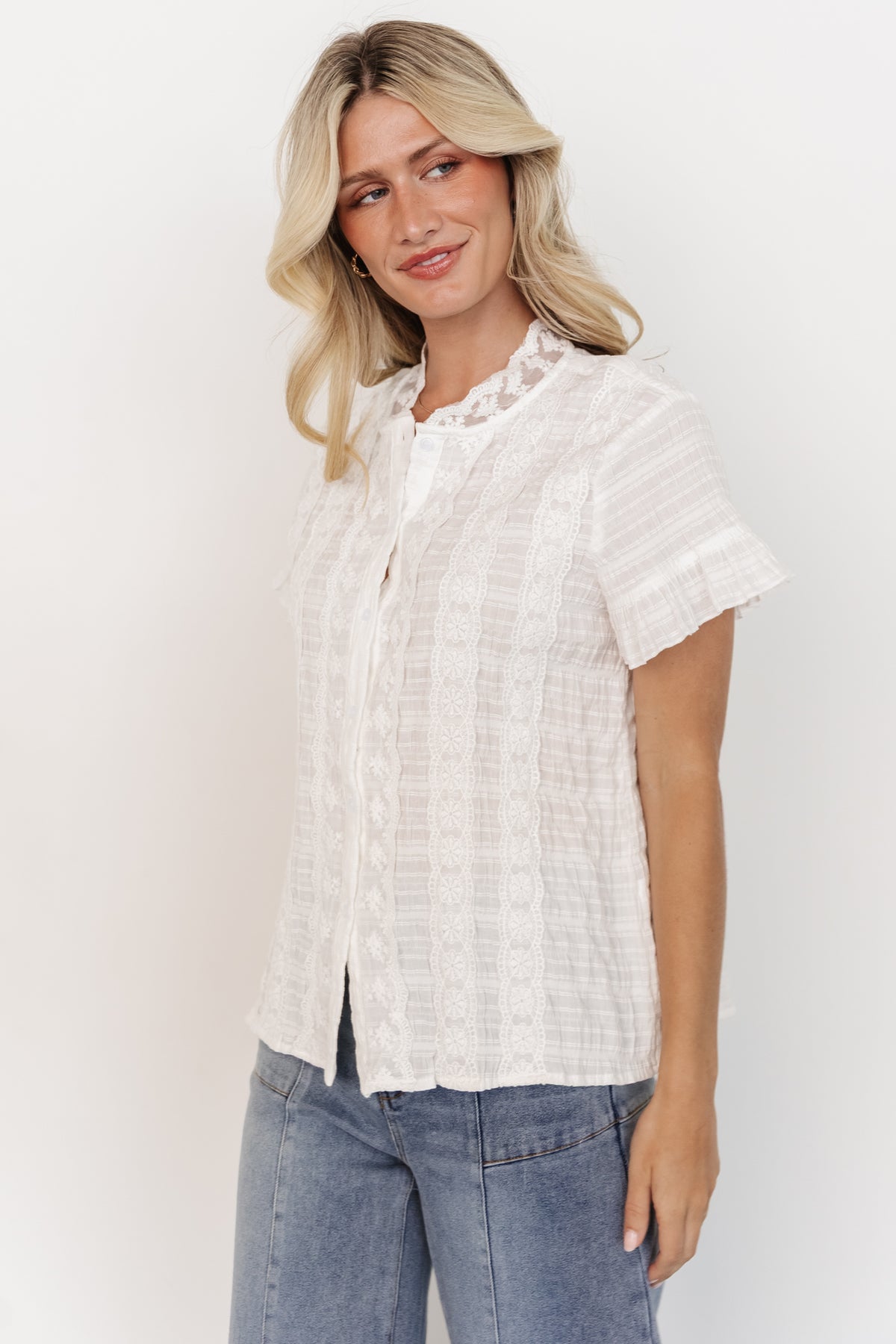 Detail shot of the Zara Lace Top sleeve and hem emphasizing the short ruffle sleeve, stitch detail, and textured cotton material.