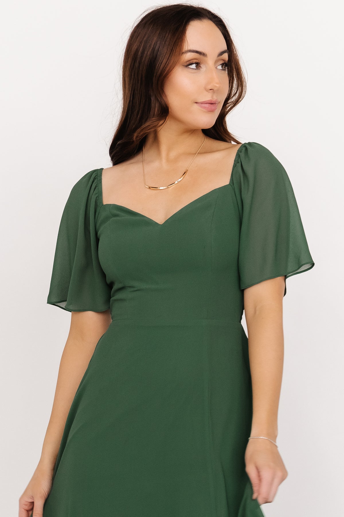Flat lay of Sierra Chiffon swatch in Evergreen beside a neutral background, highlighting drape, edge finish, and color depth.