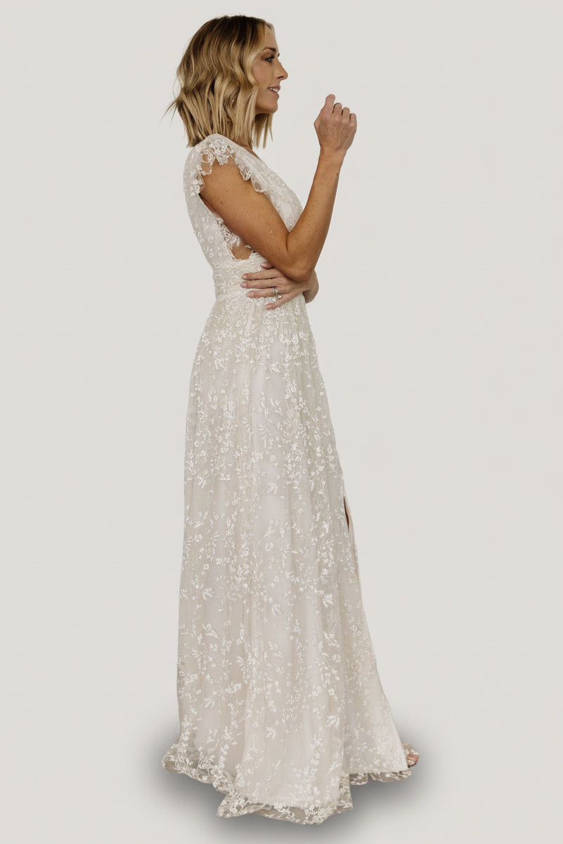 Close-up of the shimmering floral pattern on ivory tulle overlay, showing sparkle, texture, and layered construction of the gown.
