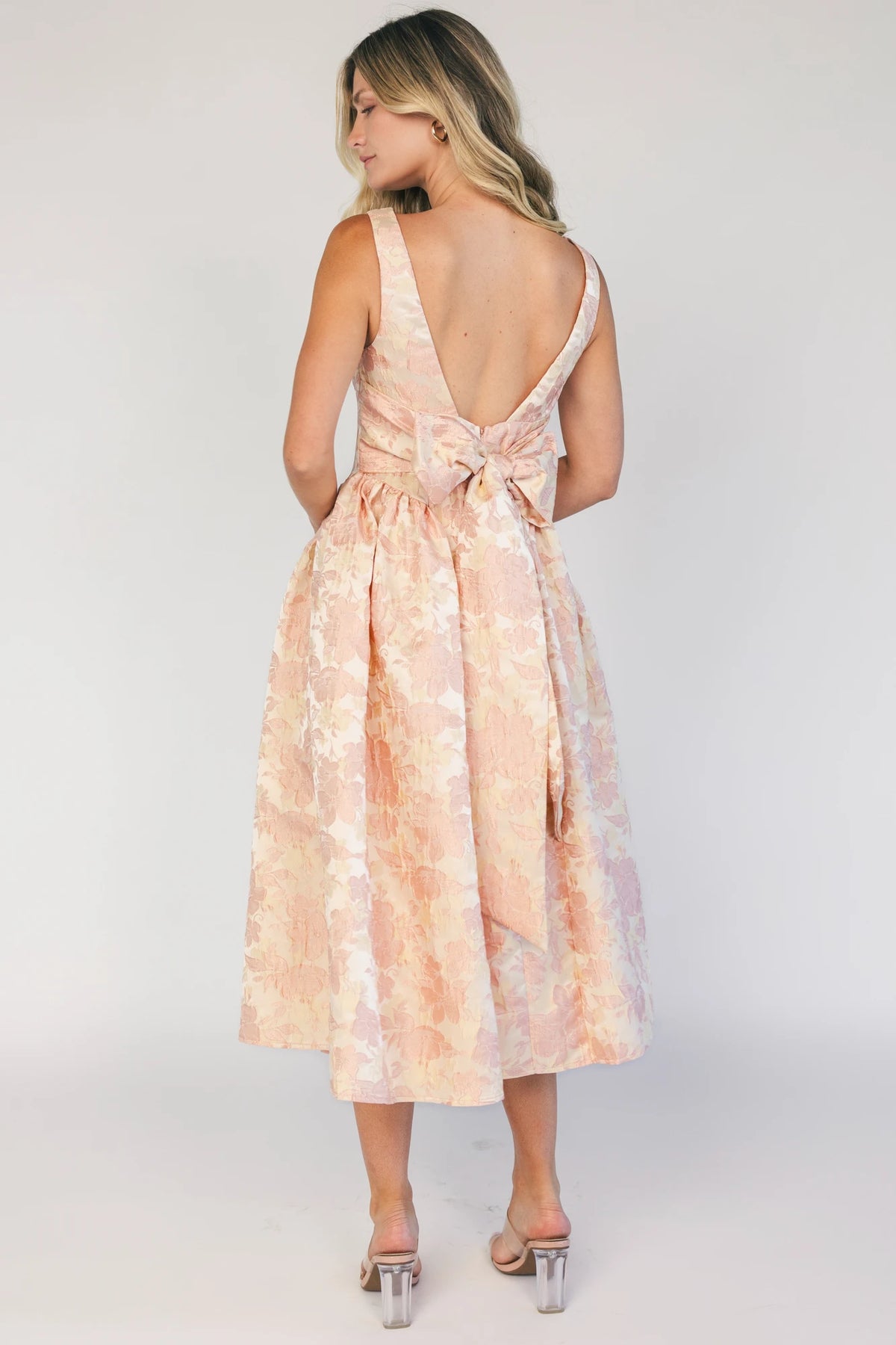Model wearing a peach floral jacquard midi dress with a square neckline, wide tank straps, and a fitted bodice.