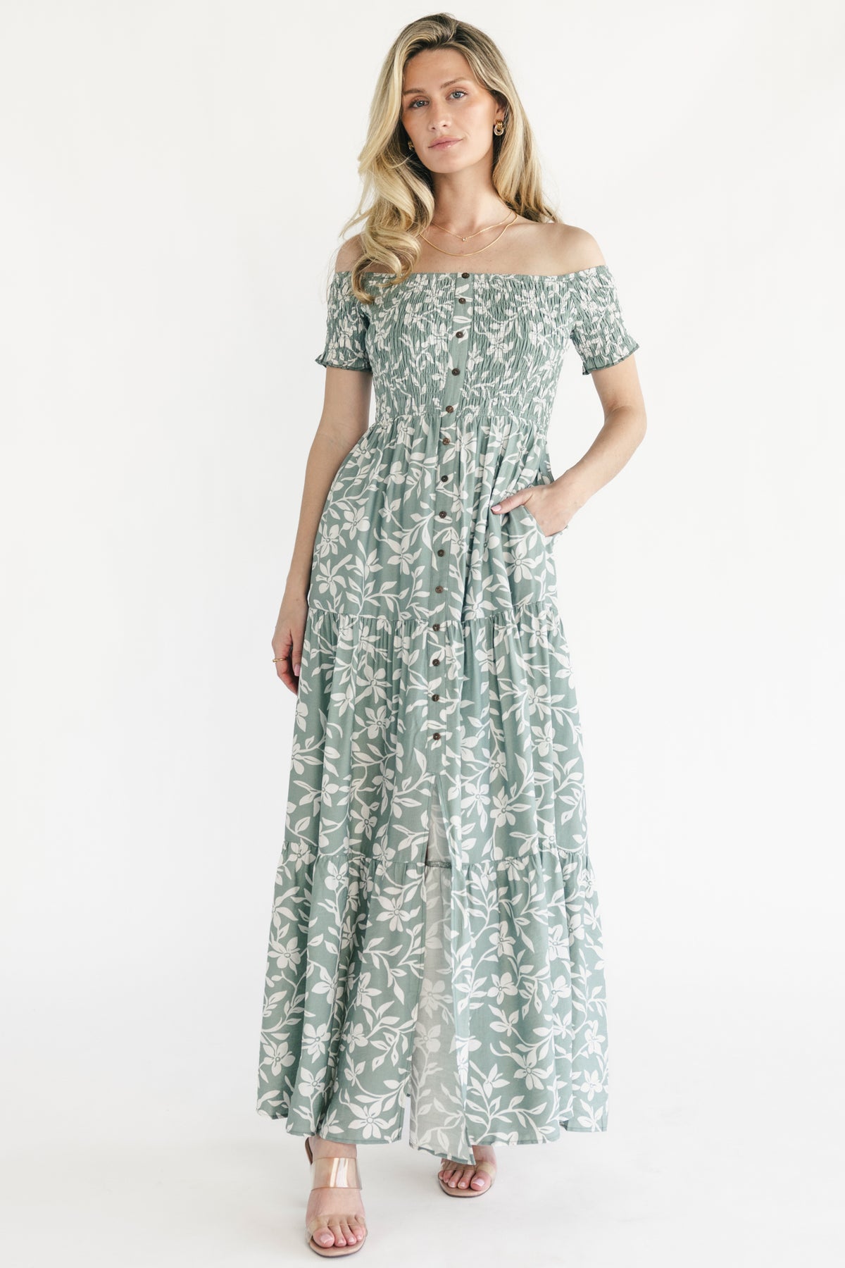 Front view of Payton off-shoulder maxi dress in dusty sage with ivory floral print, showing smocked bodice and button-front detail.