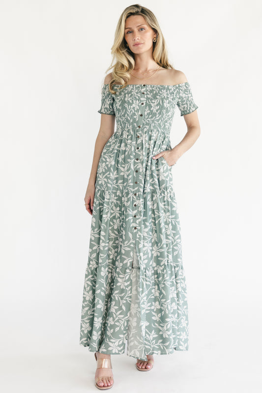 Front view of Payton off-shoulder maxi dress in dusty sage with ivory floral print, showing smocked bodice and button-front detail.