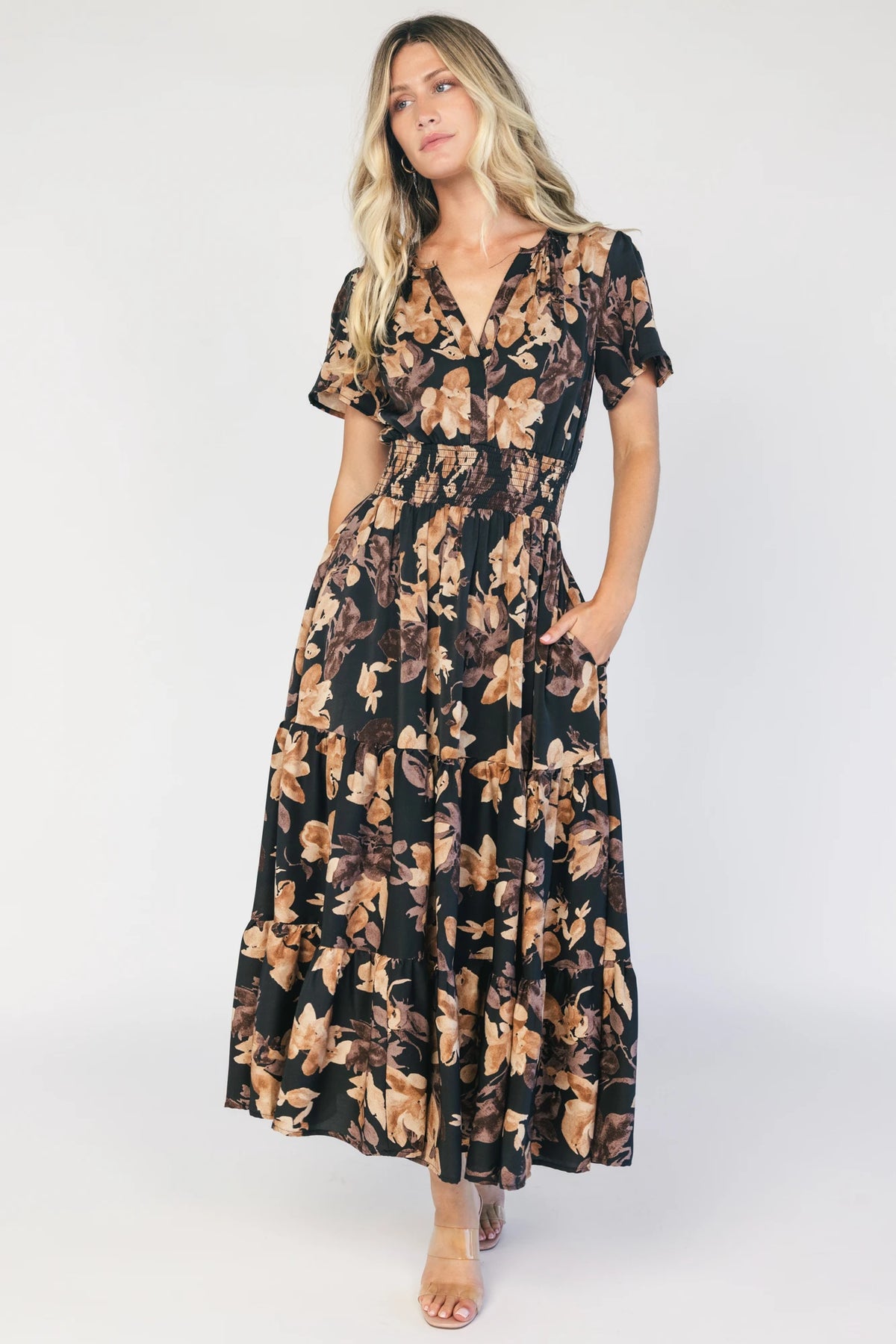 Model wearing a black floral midi dress with a V-neckline, short flutter sleeves, and a smocked waistband.