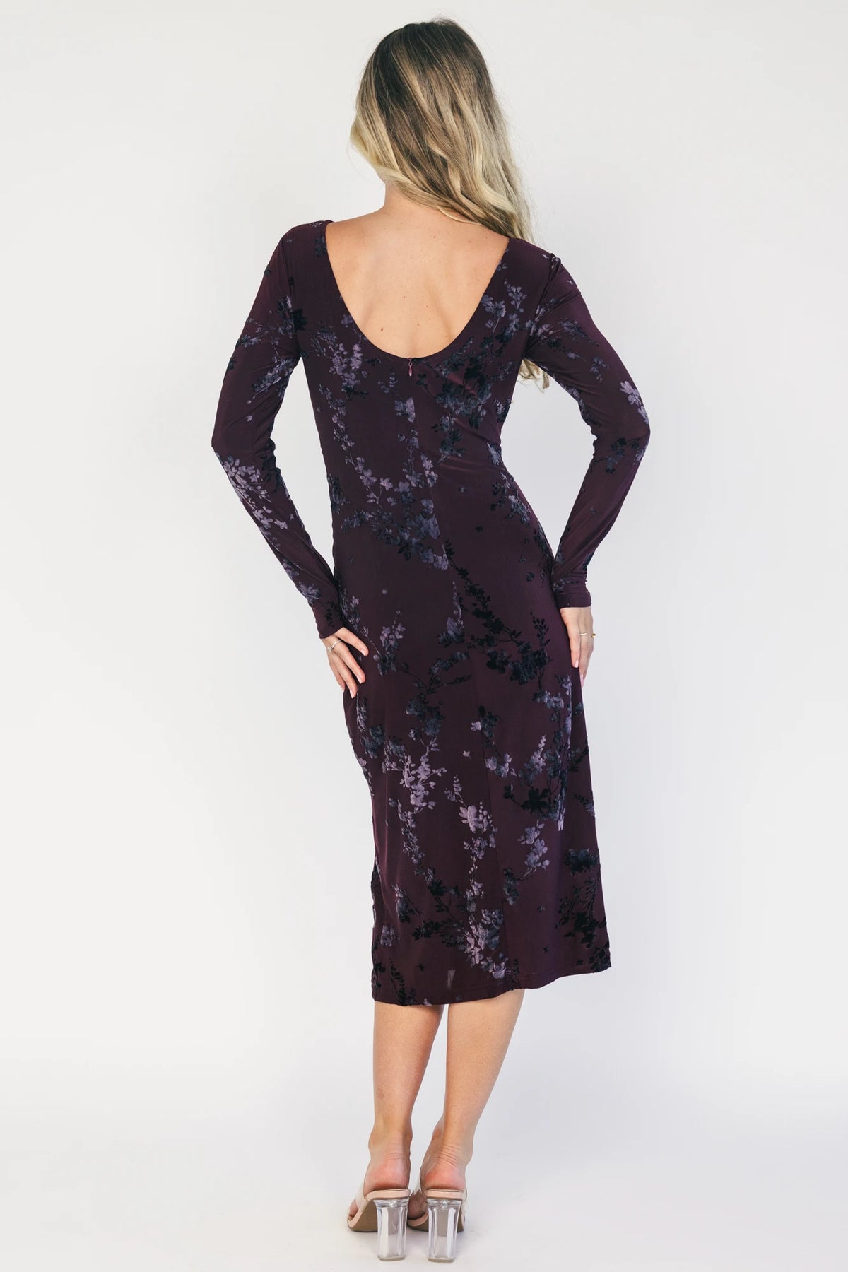 Model wearing a dark plum velvet floral midi dress with a boat neckline, long sleeves, and a fitted silhouette.