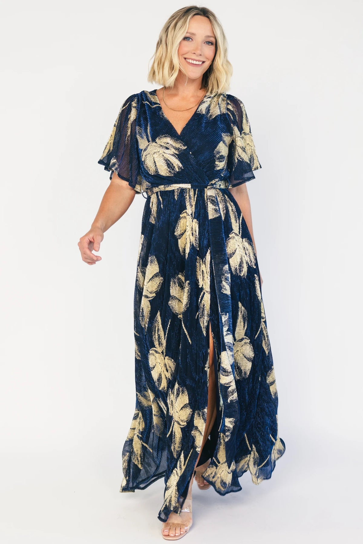 Rachel Maxi Dress in Navy + Gold with shimmer finish, surplice neckline, self-tie sash, long sleeves, and leg slit.