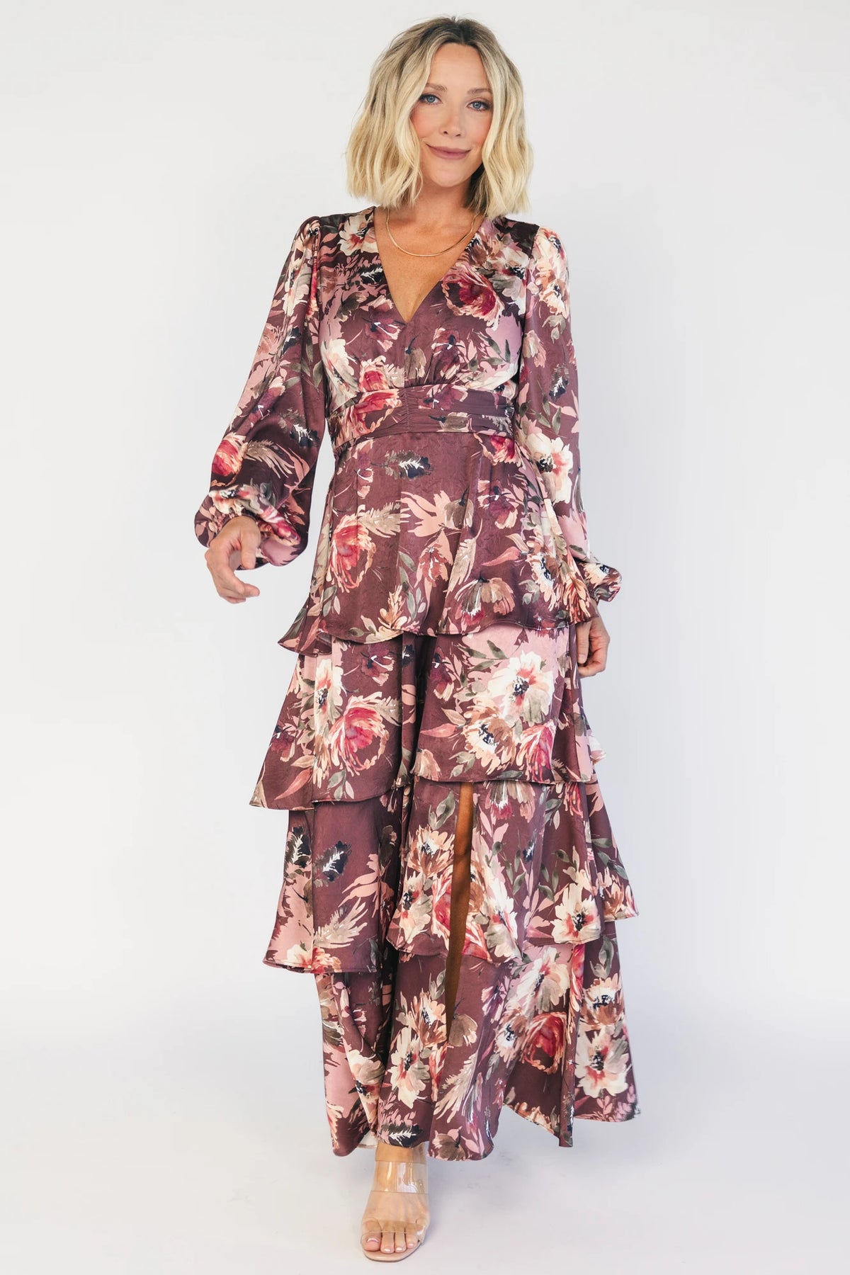 Clove satin maxi dress with a mauve floral print, V-neckline, short sleeves, a smocked back, and a flowing tiered ruffle skirt.
