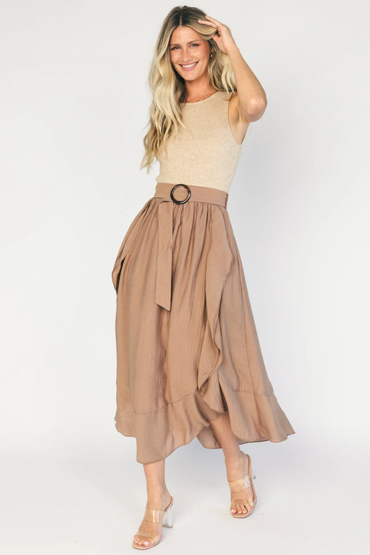 Model wearing the Stacy Midi Dress in Taupe + Mocha featuring a ribbed taupe knit bodice with a bateau neckline and a flowing woven midi skirt.