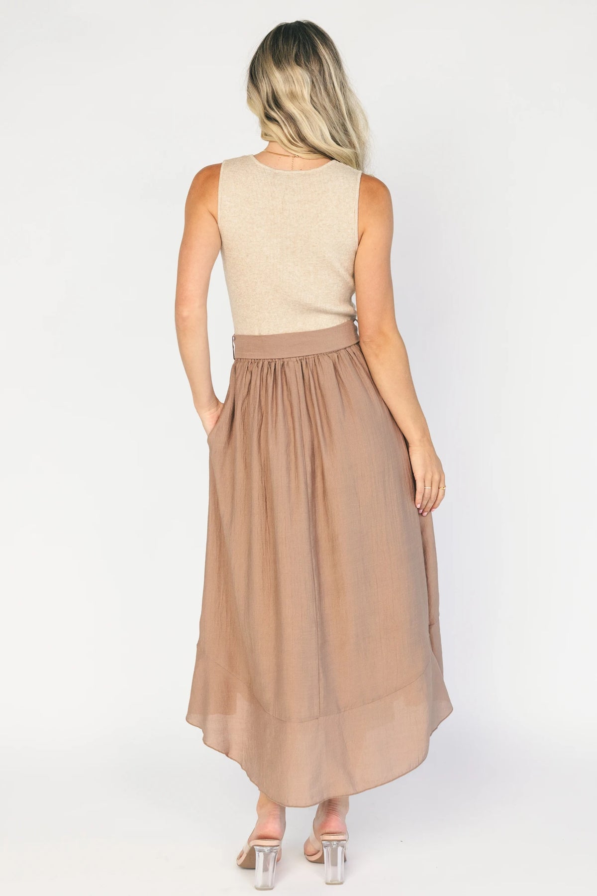 Model wearing the Stacy Midi Dress in Taupe + Mocha featuring a ribbed taupe knit bodice with a bateau neckline and a flowing woven midi skirt.
