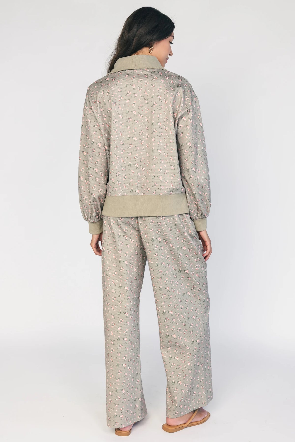 Model wearing the Diana Lounge Set in Olive Floral featuring a matching long-sleeve half-zip top and wide-leg pants.