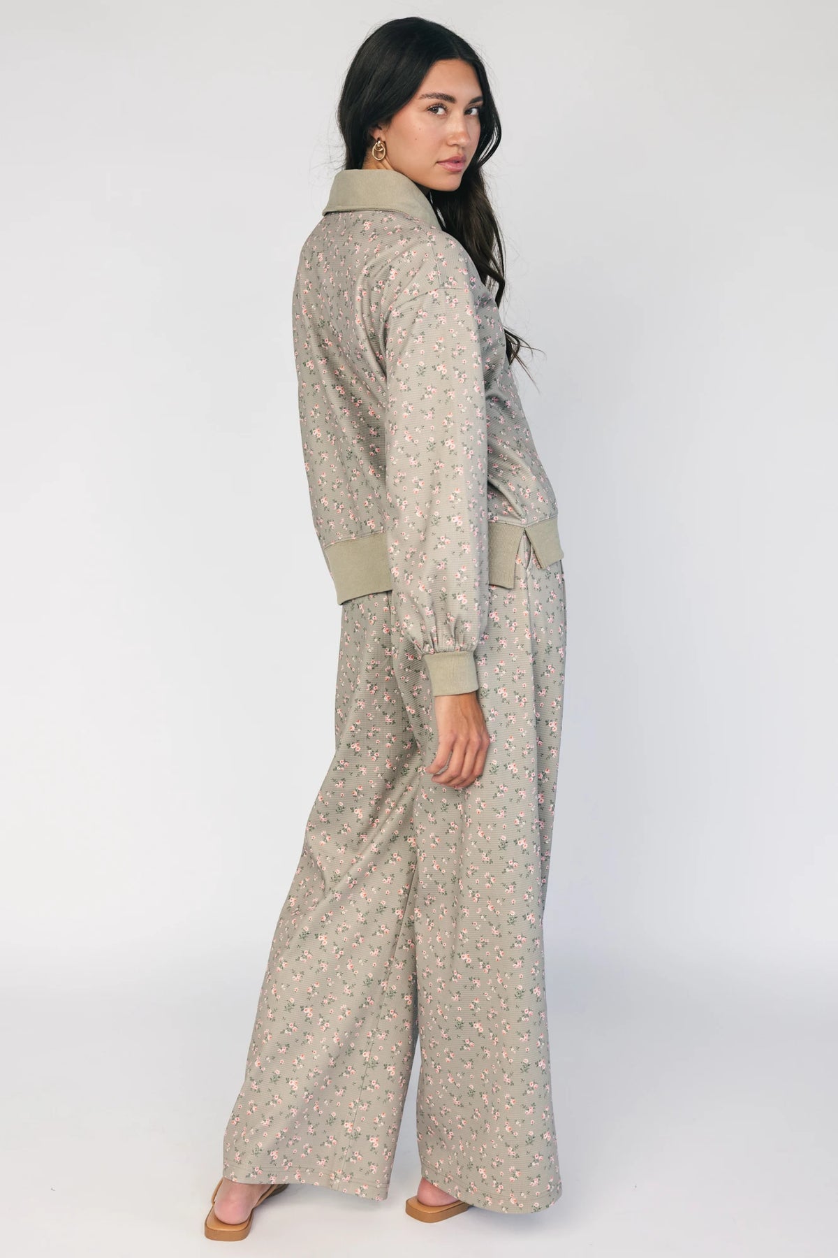 Model wearing the Diana Lounge Set in Olive Floral featuring a matching long-sleeve half-zip top and wide-leg pants.