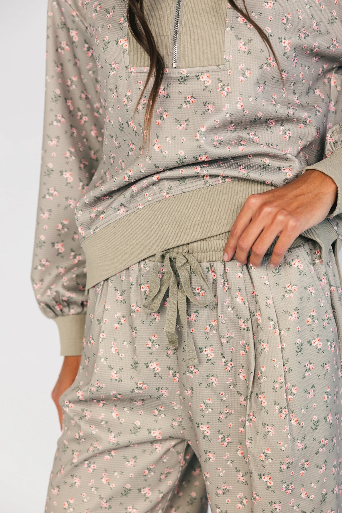 Model wearing the Diana Lounge Set in Olive Floral featuring a matching long-sleeve half-zip top and wide-leg pants.