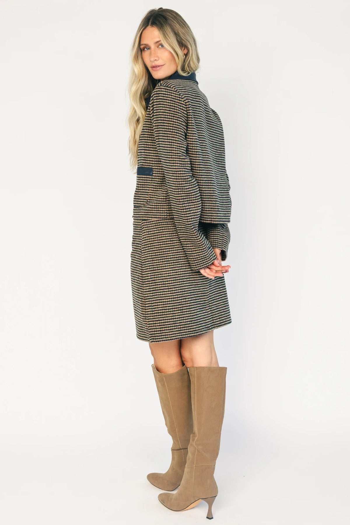Model wearing the Gracey Set in Navy + Tan featuring a navy and tan striped tweed jacket with a collared neckline, faux leather trim, button-front closure, and matching mini skirt for a polished, coordinated look.