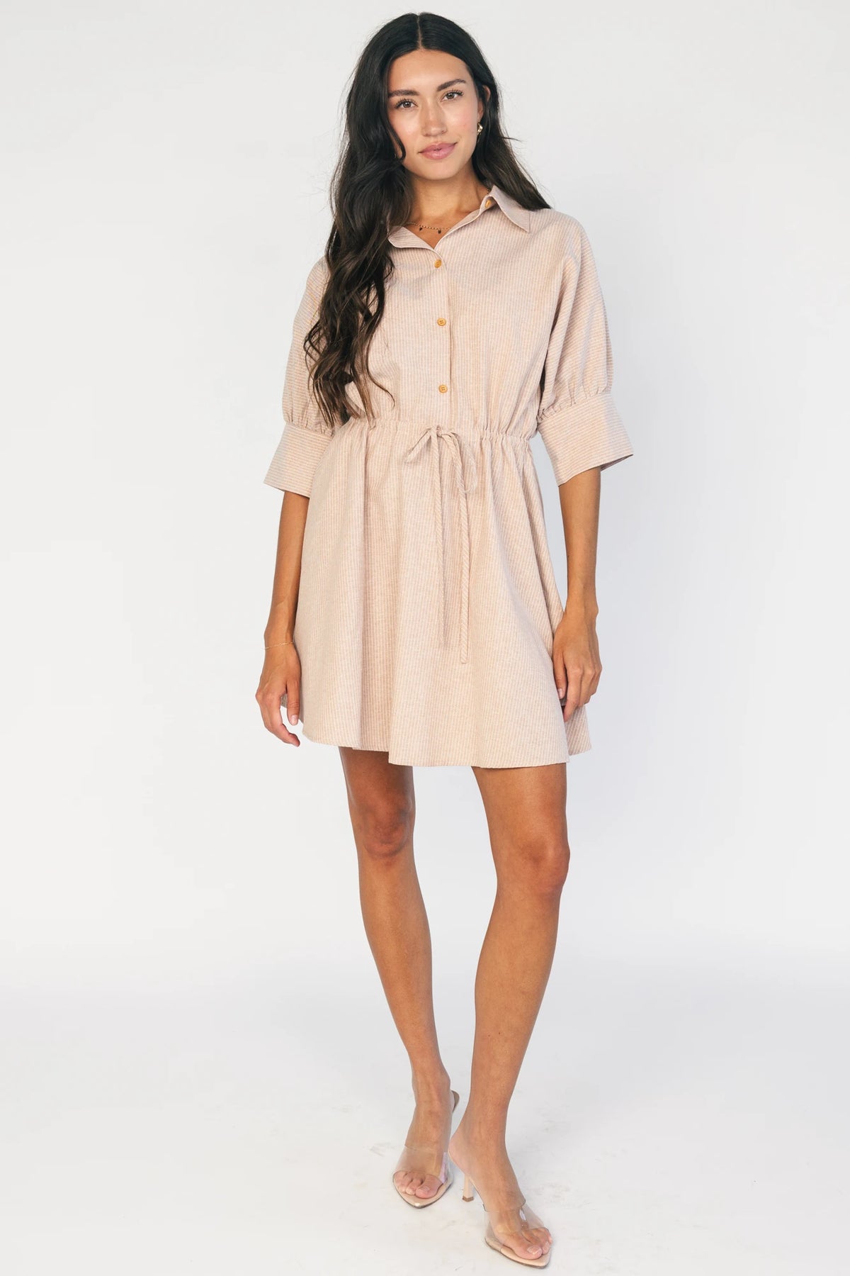 Model wearing the Beekman Short Dress in Natural Stripe featuring a collared neckline, functional button-front closure, elbow-length sleeves with wide cuffs, and a removable waist tie.