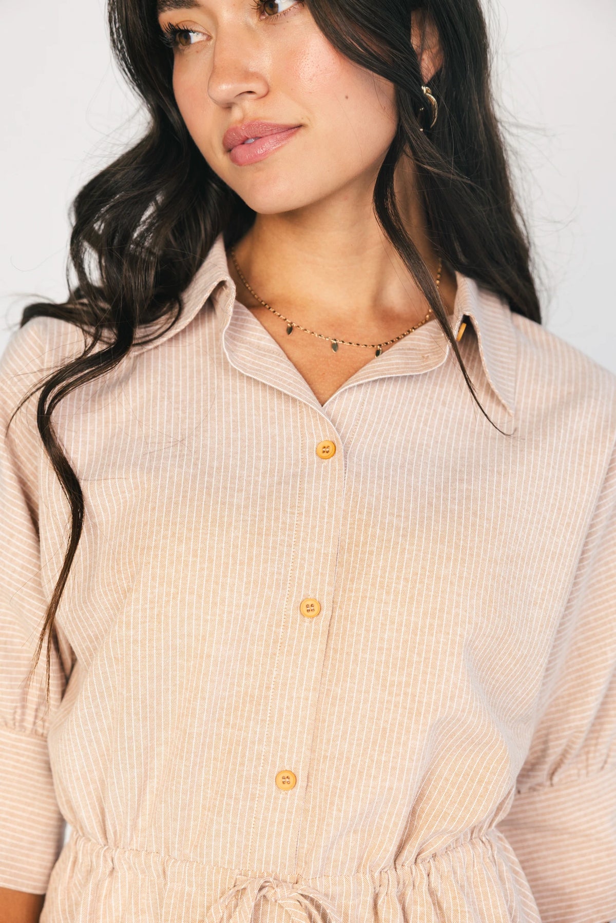 Model wearing the Beekman Short Dress in Natural Stripe featuring a collared neckline, functional button-front closure, elbow-length sleeves with wide cuffs, and a removable waist tie.