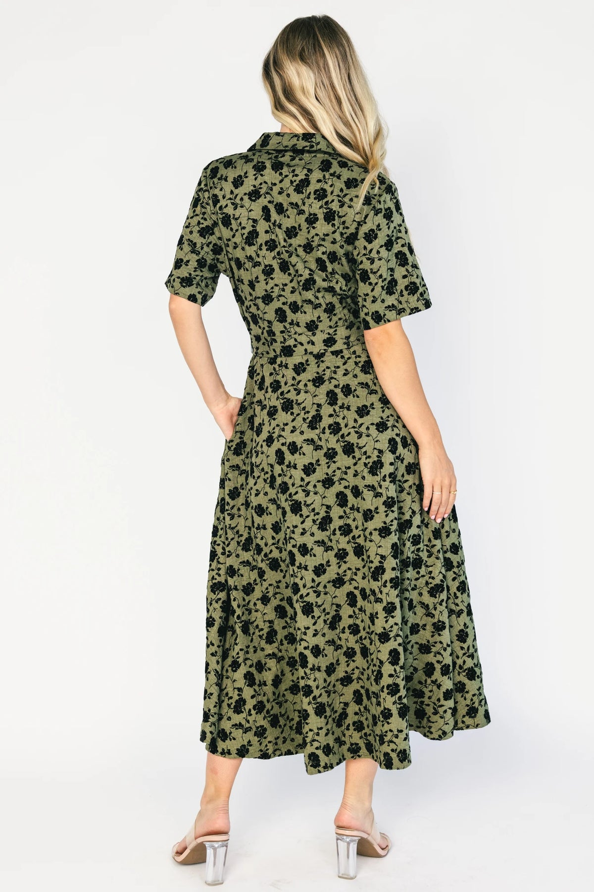 Deep olive floral midi shirt dress with a collared neckline, button-front closure, short sleeves, removable waist tie, side pockets, and fit-and-flare skirt.