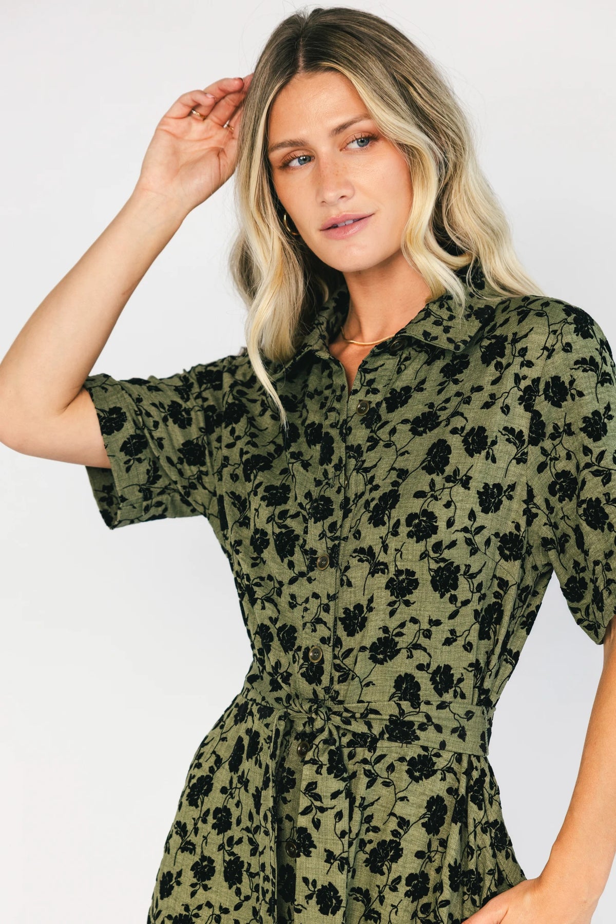 Deep olive floral midi shirt dress with a collared neckline, button-front closure, short sleeves, removable waist tie, side pockets, and fit-and-flare skirt.