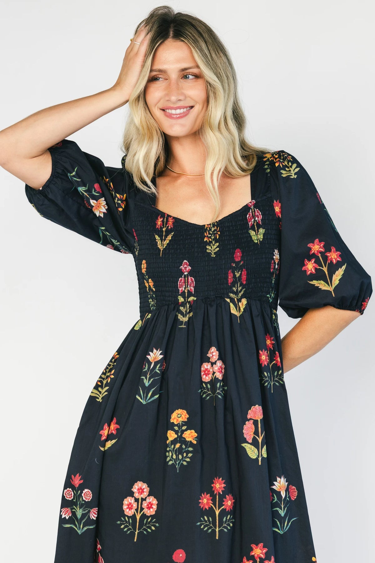 Navy floral maxi dress with a V-neckline, short puff sleeves, empire waist, fit-and-flare skirt, and contrast border hem.