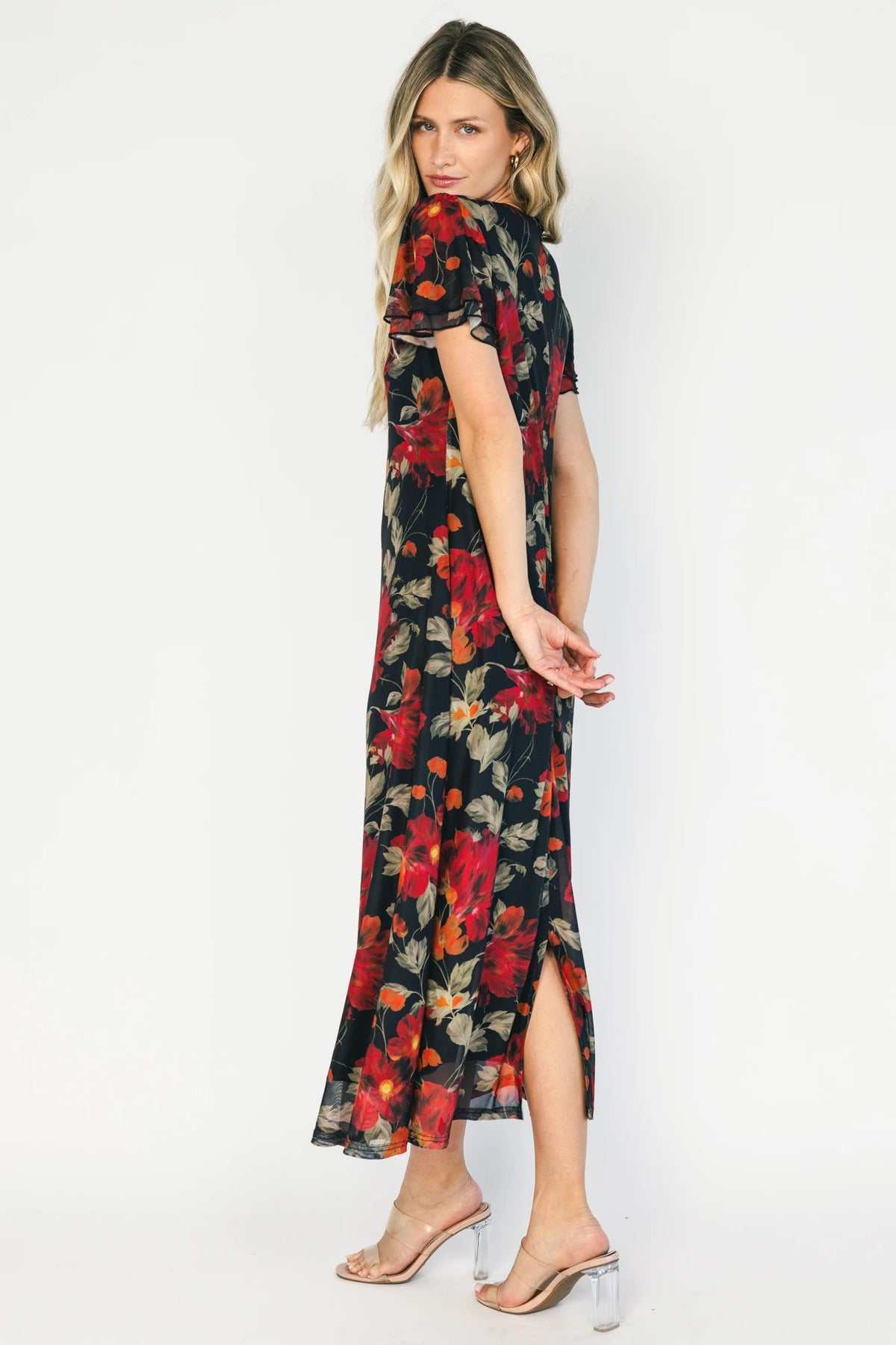 Black floral mesh maxi dress with a round neckline, layered flutter sleeves, bias-cut silhouette, and flowing full-length skirt.