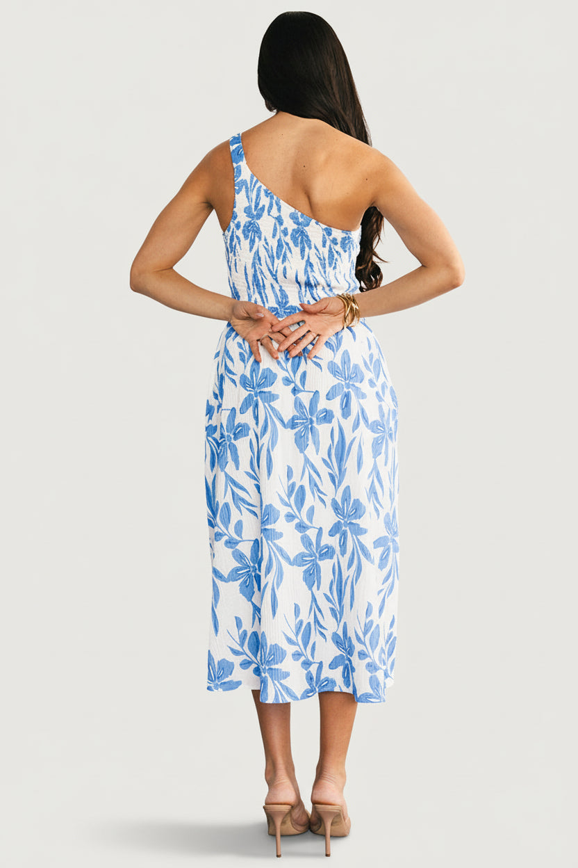 Detail shot of the crinkled lightweight fabric with white and blue floral pattern, demonstrating texture and gentle movement of the material.