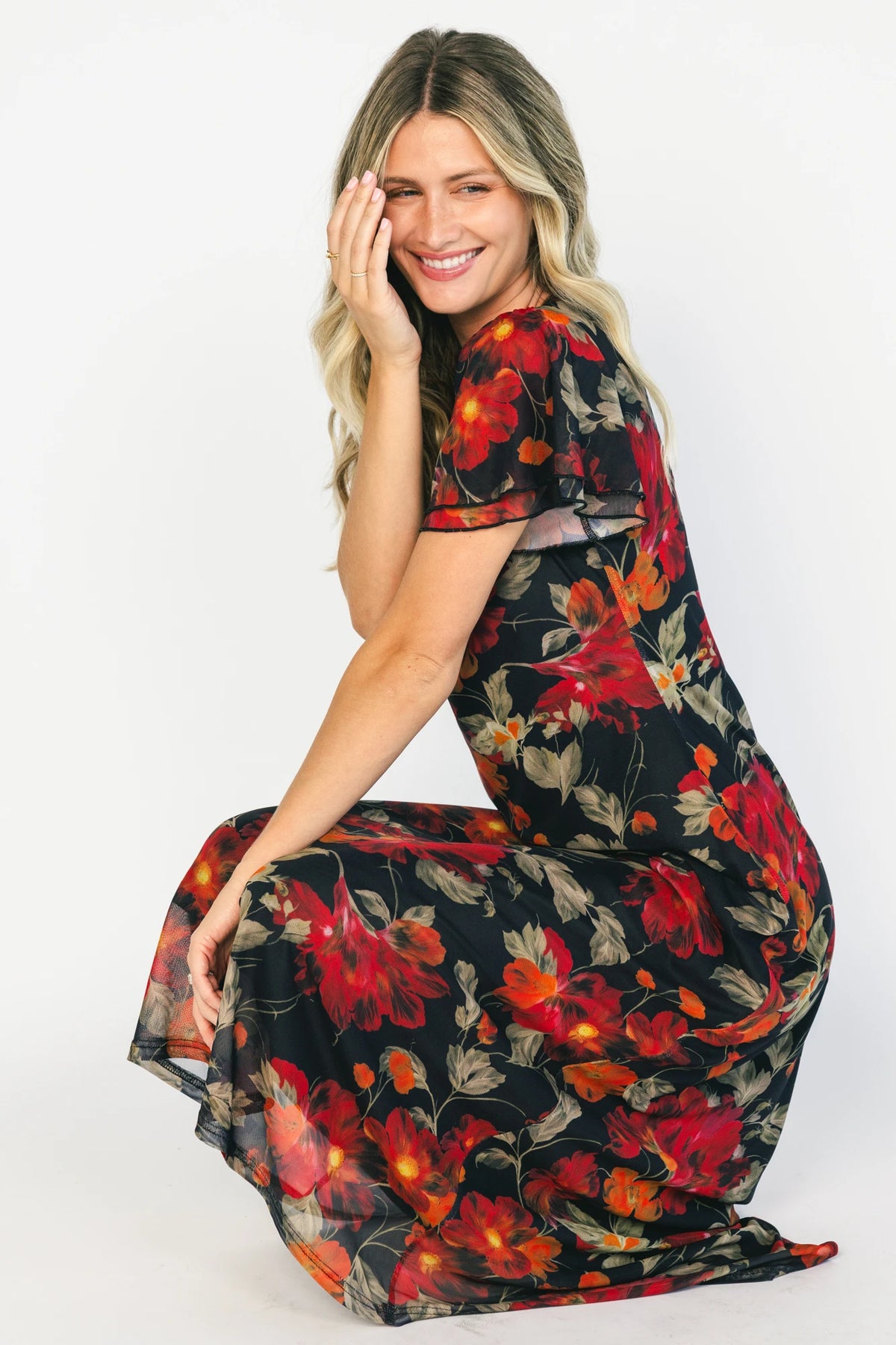 Black floral mesh maxi dress with a round neckline, layered flutter sleeves, bias-cut silhouette, and flowing full-length skirt.