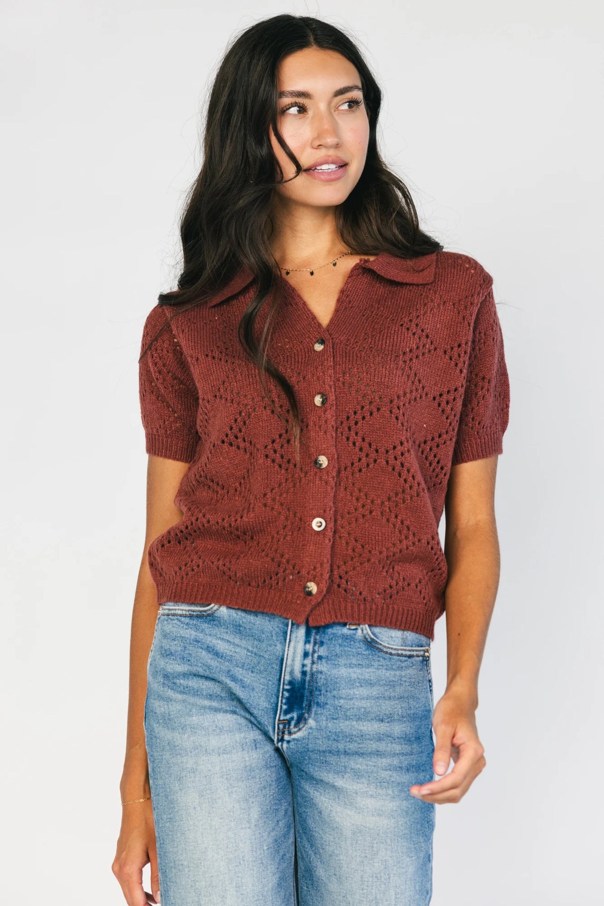 Model wearing a dark clay openwork knit cardigan with a V-neckline, short sleeves, five-button front closure, and a relaxed silhouette.