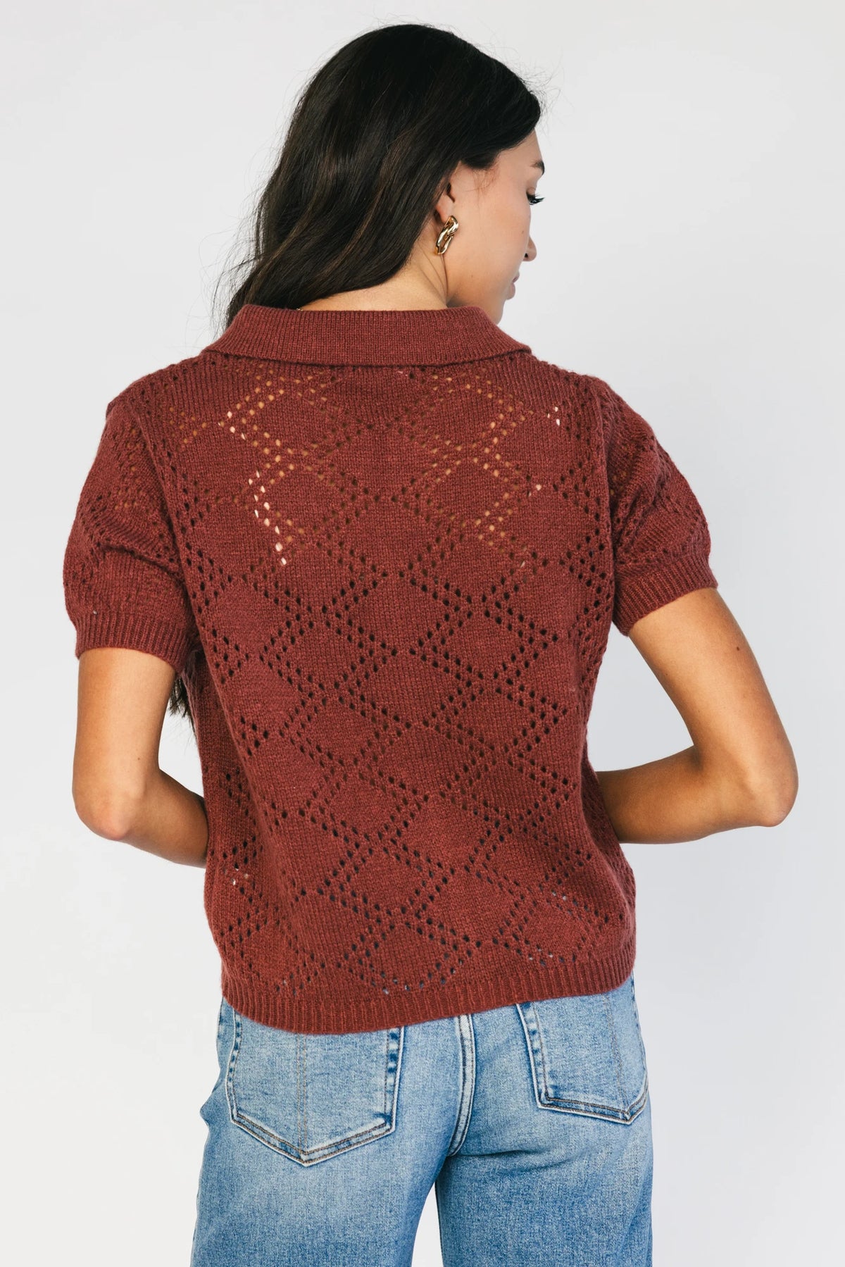 Model wearing a dark clay openwork knit cardigan with a V-neckline, short sleeves, five-button front closure, and a relaxed silhouette.