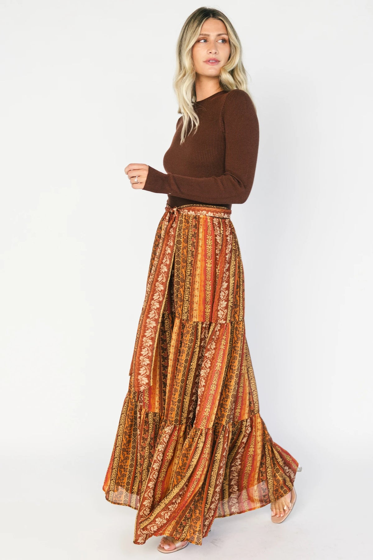 Brown ribbed sweater maxi dress with long sleeves, a high round neckline, removable waist tie, and a flowing multicolor chiffon skirt.