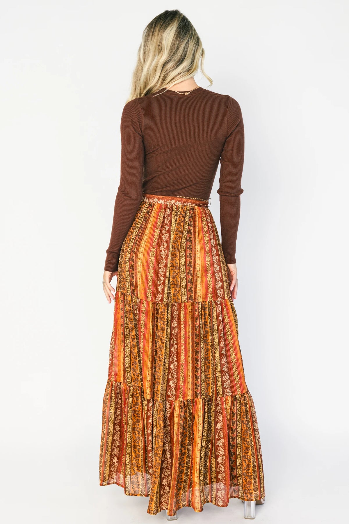 Brown ribbed sweater maxi dress with long sleeves, a high round neckline, removable waist tie, and a flowing multicolor chiffon skirt.