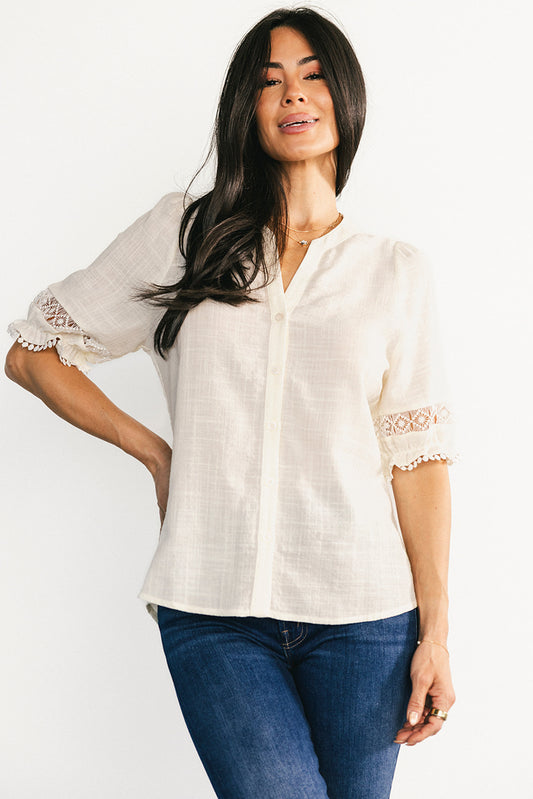 Front view of Alba Button Up Top in true ivory, highlighting the notched V-neck, button-front placket, and relaxed high-low hem for versatile styling.