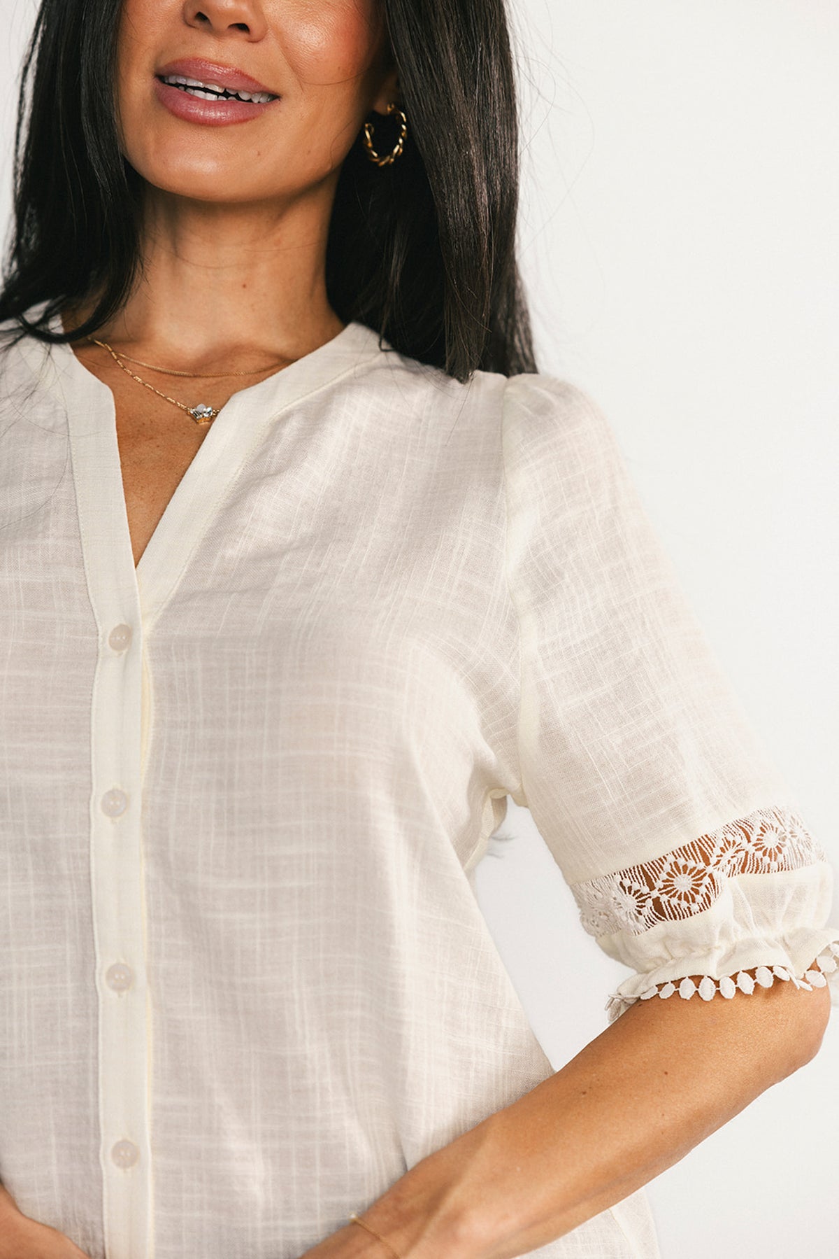 Back and side view of the Alba Button Up Top in ivory, showing the high-low hemline, relaxed silhouette, and how it layers easily over skirts or jeans.