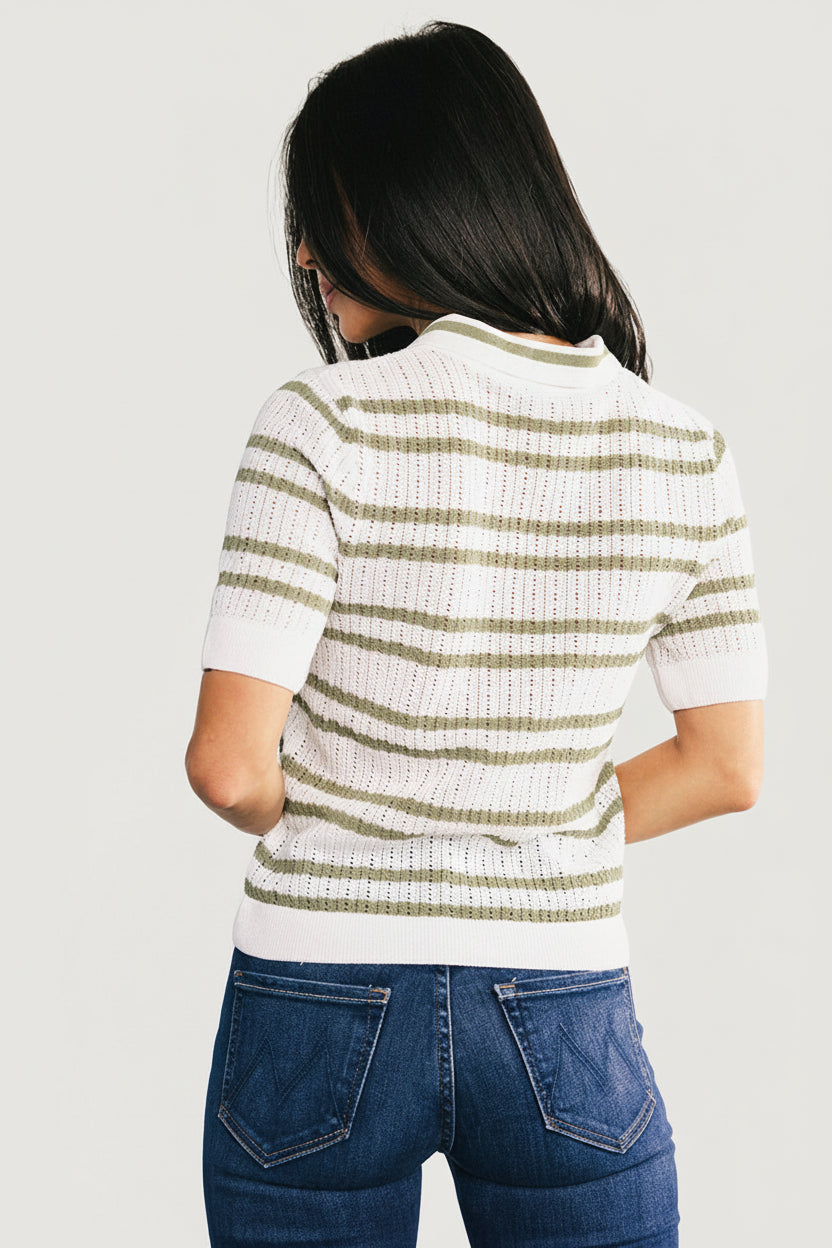 Side view of Bahía knit stripe top worn by a model, highlighting relaxed fit, hemline, sleeve length, and sage-on-off-white stripe pattern.