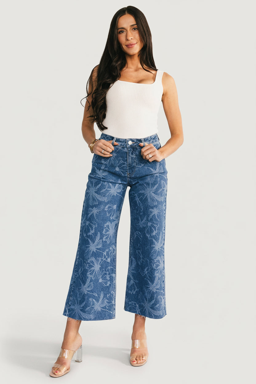 Back view of Cádiz jeans on model showing functional back pockets, mid-rise waistband, and raw frayed hem detail (approx. 100 chars)
