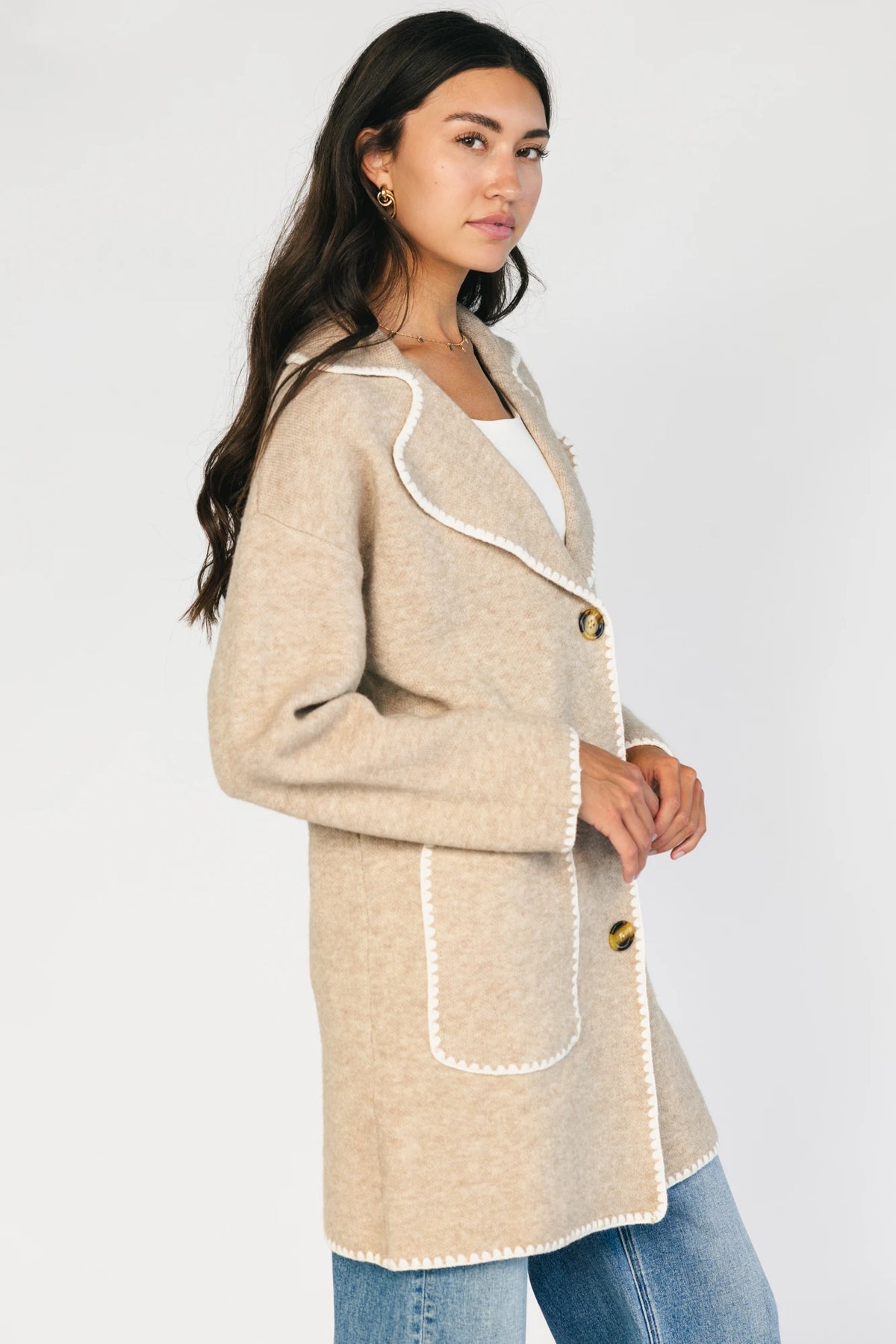 Taupe collared knit cardigan with cream contrast trim, a button-front closure, long sleeves, and two front patch pockets in a relaxed, shirt-style silhouette.