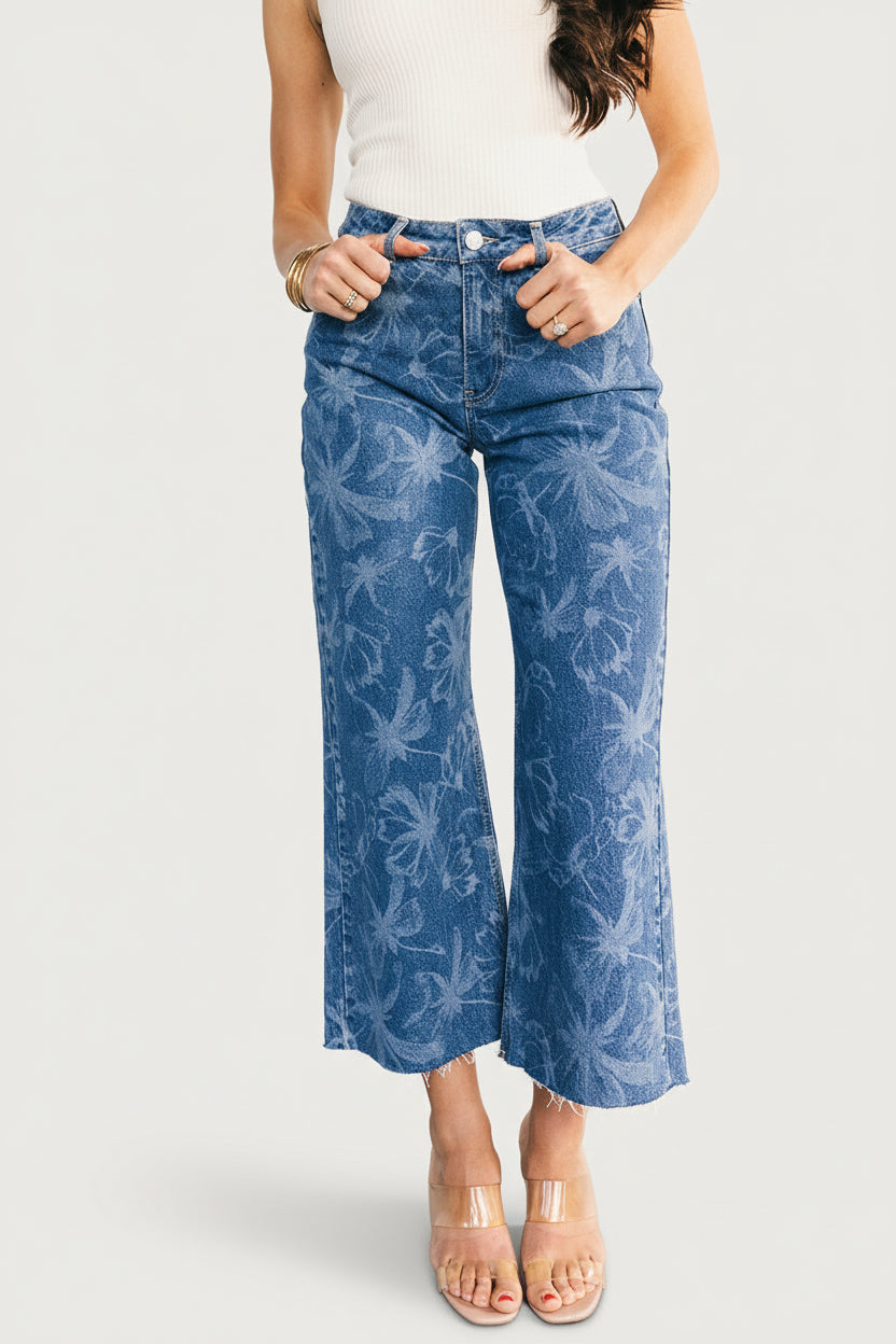 Front view of mid-rise relaxed jeans in medium floral wash on model, straight cropped leg and raw frayed hem, studio background (approx. 100 chars)