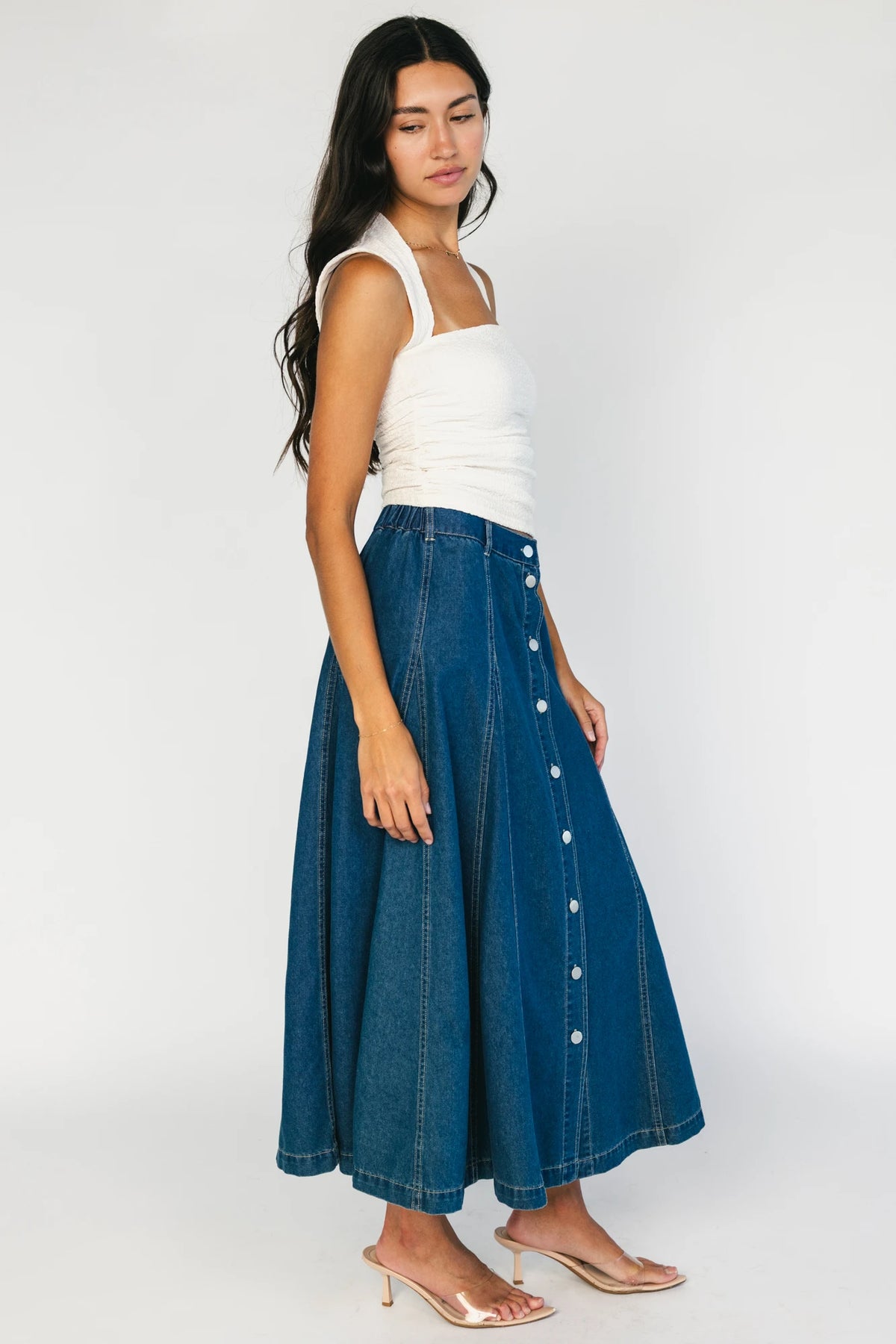 Model wearing the Cece Button-Down Denim Skirt in a dark wash featuring a button-front placket, elastic back waist, and a classic knee-length silhouette.