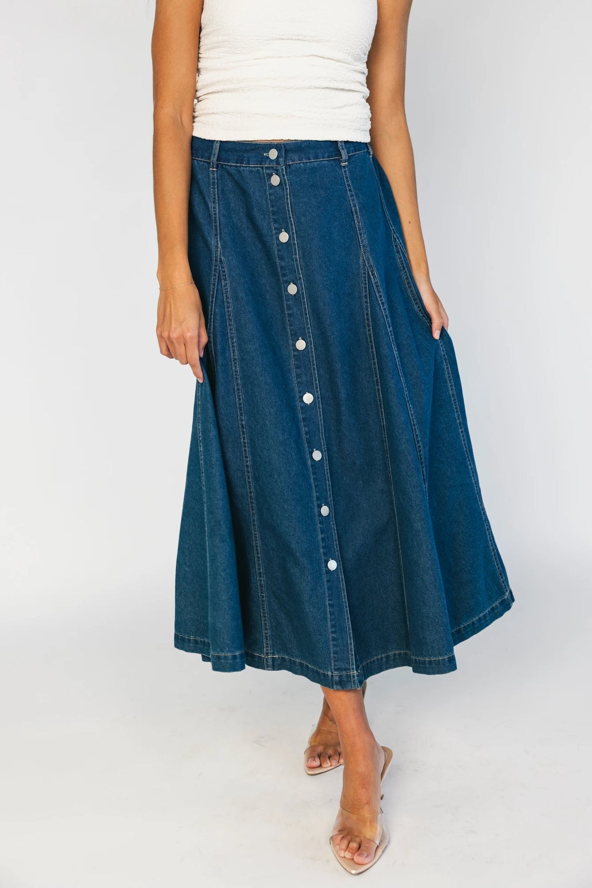 Model wearing the Cece Button-Down Denim Skirt in a dark wash featuring a button-front placket, elastic back waist, and a classic knee-length silhouette.