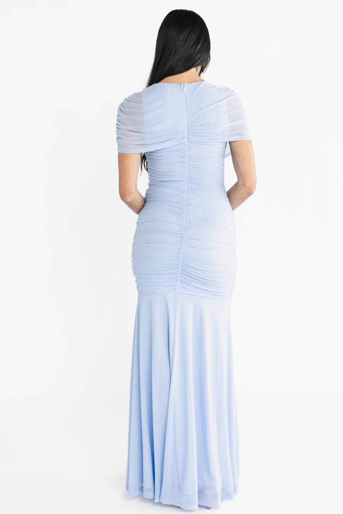 Side profile of the Serenade Maxi Dress in light blue, showing short asymmetrical sleeve, mermaid hemline and smooth silhouette.