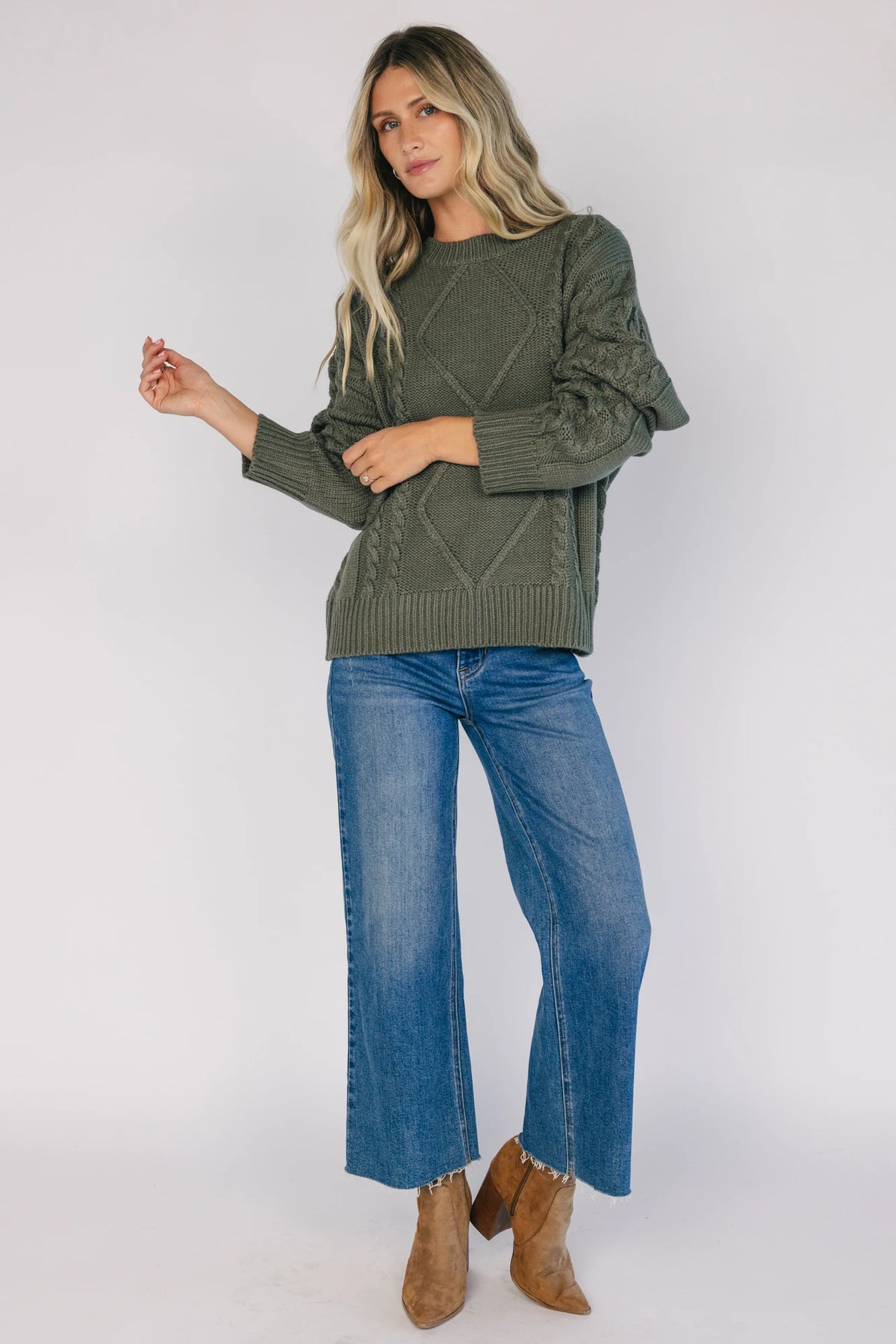 Model wearing an olive knit sweater with a round neckline, long drop-shoulder sleeves, and ribbed trim at the neckline, cuffs, and hem.