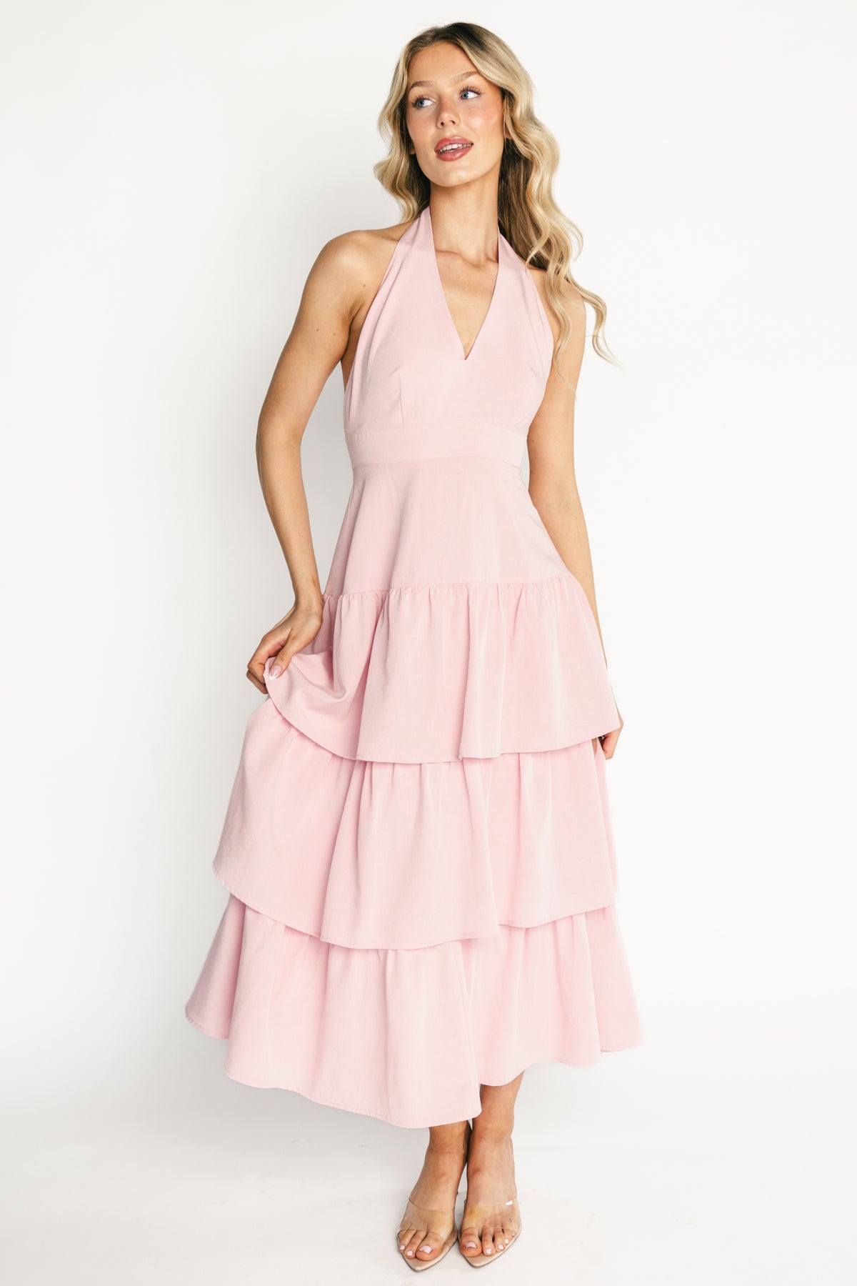 Front view of Savannah Tiered Halter Maxi Dress in light pink on model, showing deep V halter neckline, banded empire waist and tiered ruffled skirt.