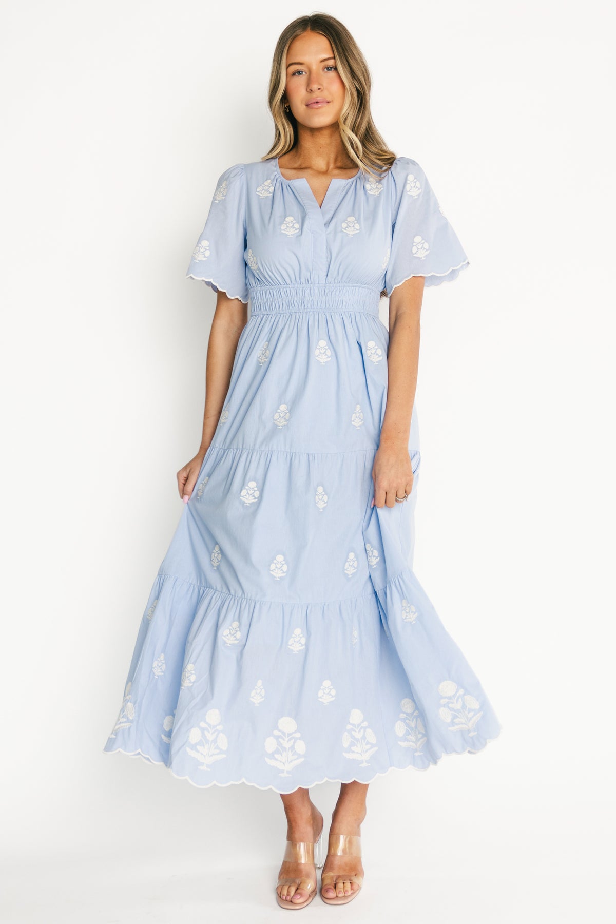 Back and side view of the Delilah Embroidered Maxi Dress in light blue, showing smocked elastic waistband, tiered skirt and how the fabric drapes at the hem.
