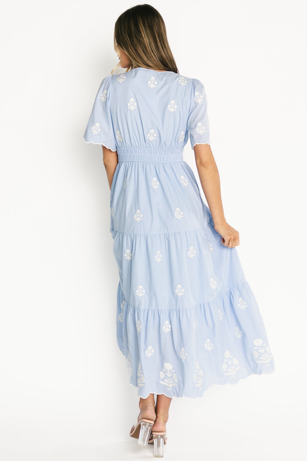 Full-length shot of the Delilah Maxi Dress in light blue worn with sandals, showcasing the ankle-length tiered skirt, pockets, and overall relaxed boho silhouette.