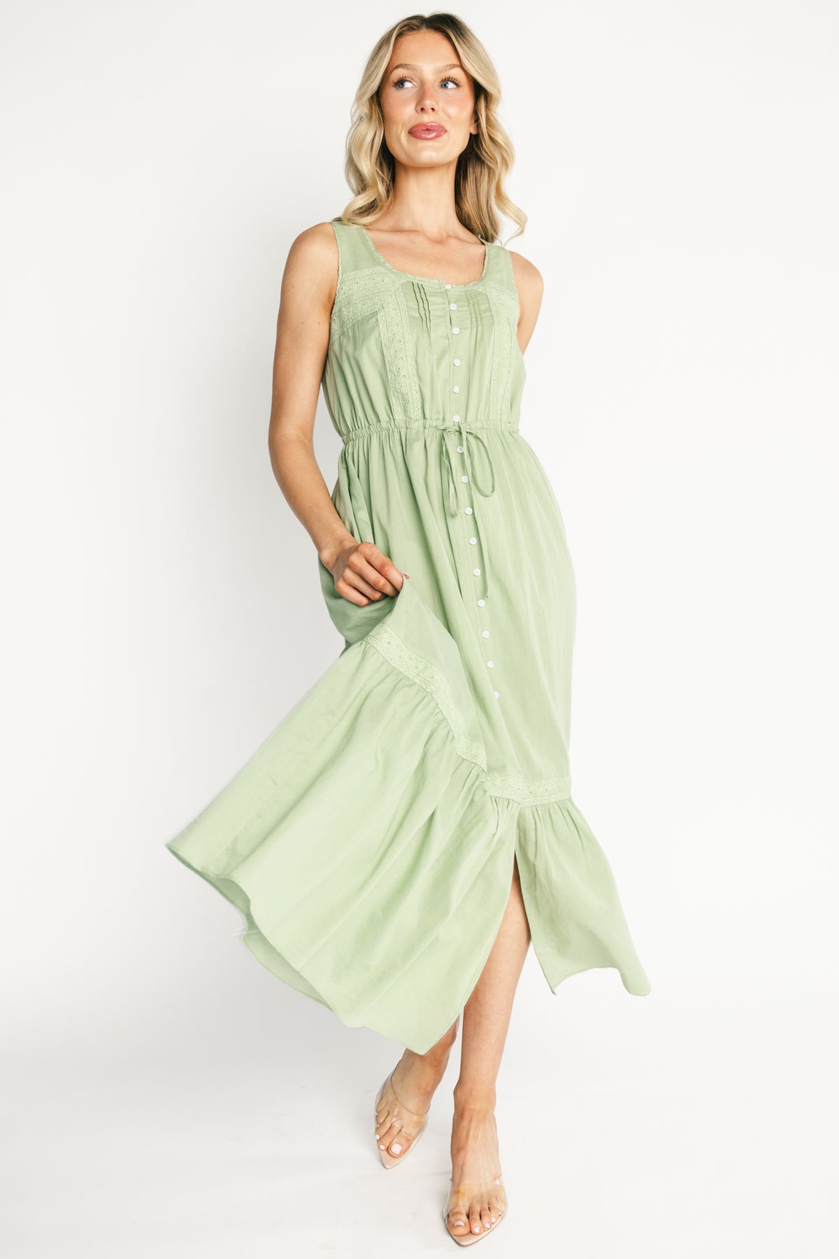 Detail shot of the adjustable drawstring waist and button placket on the Blanche midi dress in sage, emphasizing handcrafted lace accents.