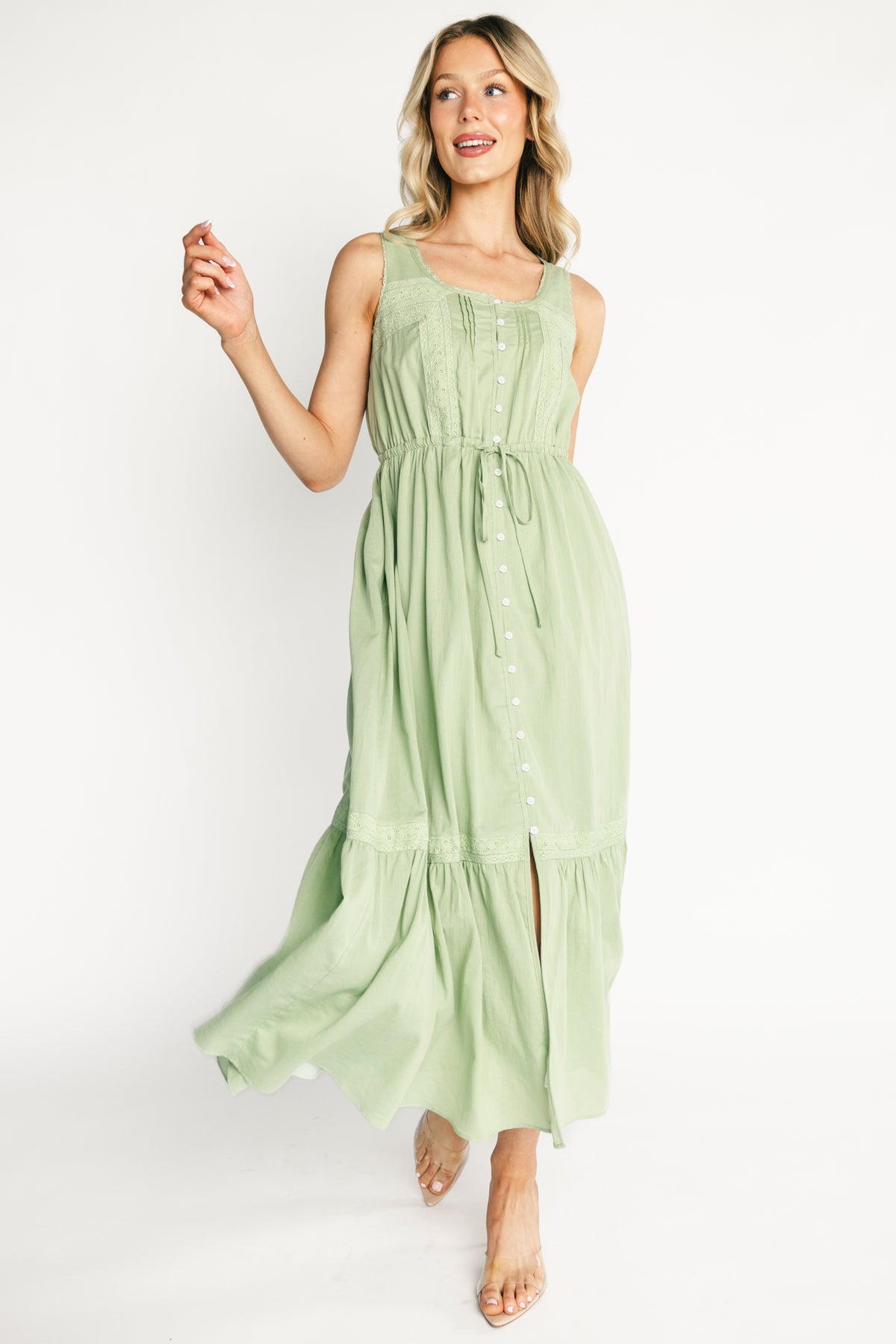 Full-length lifestyle image of model wearing the Blanche midi dress in sage, showing fit at the waist and natural drape of 100% cotton fabric.