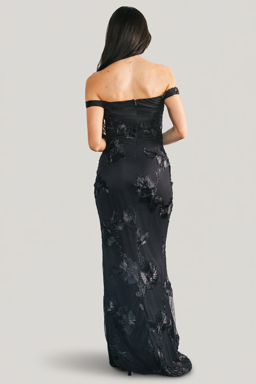 Detail view of the left leg slit and tulip skirt drape on the Kinsley black floral maxi dress showing movement and cut.
