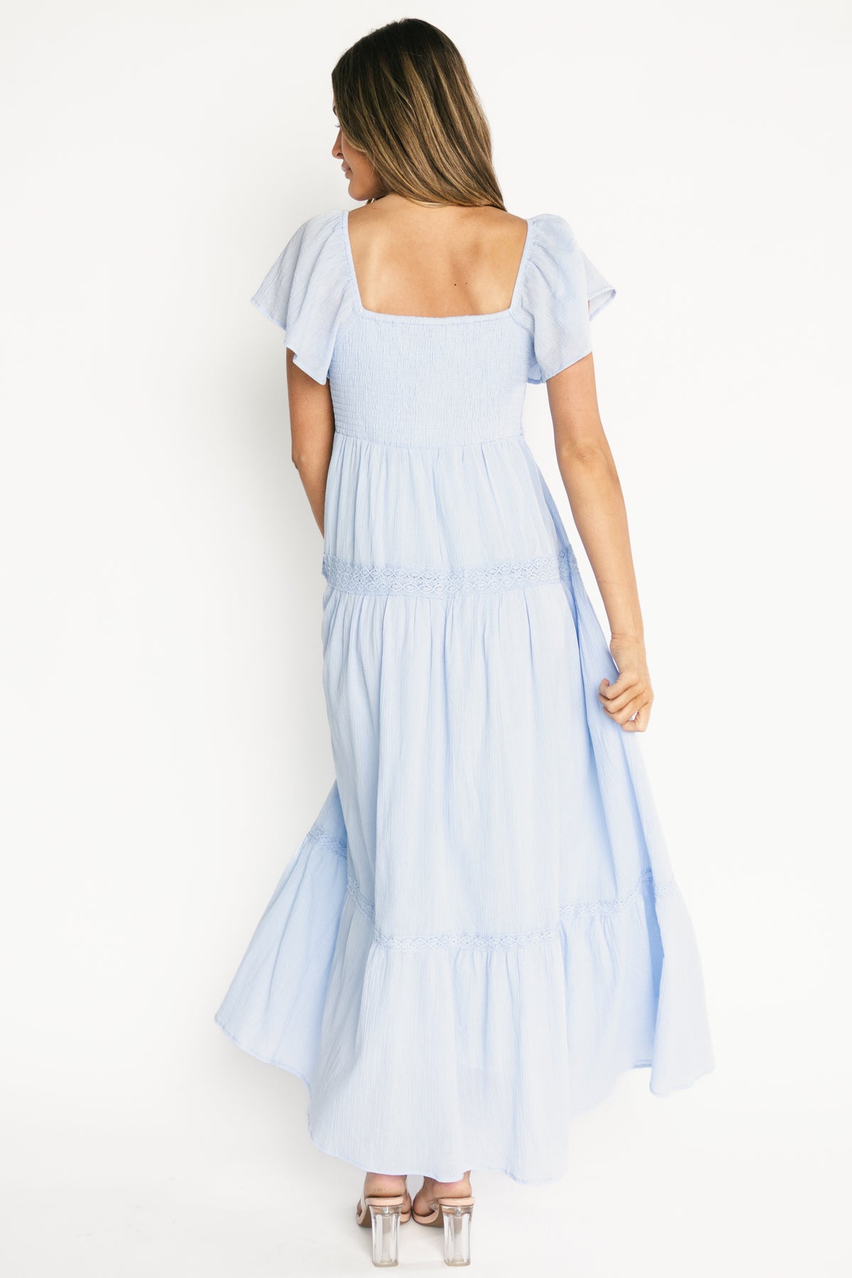 Detail of flutter sleeve and elastic shoulder, showing fabric texture and lightweight unlined sleeve in blue cotton.