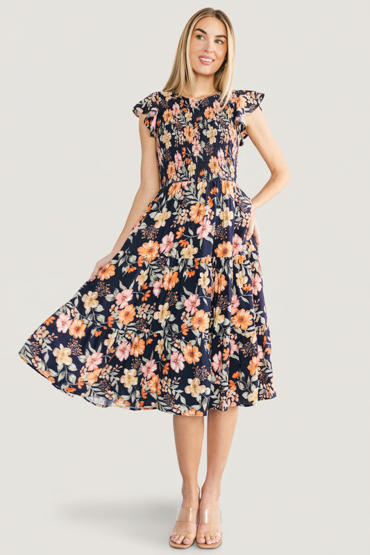 Model wearing midnight floral Loretta midi dress in a three-quarter profile, highlighting flowy three-tier skirt and natural movement.