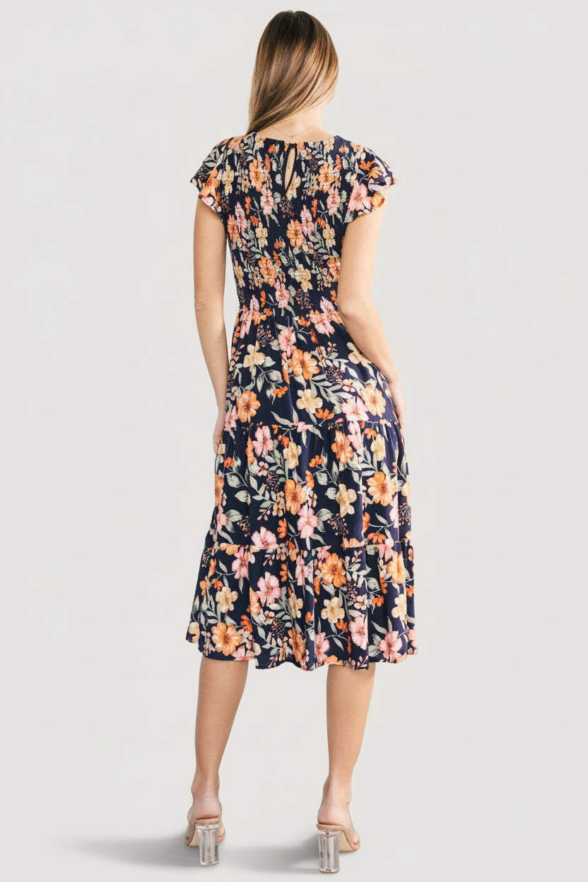 Back view of Loretta midi dress in midnight floral, displaying keyhole closure and how the smocked bodice meets the tiered skirt.