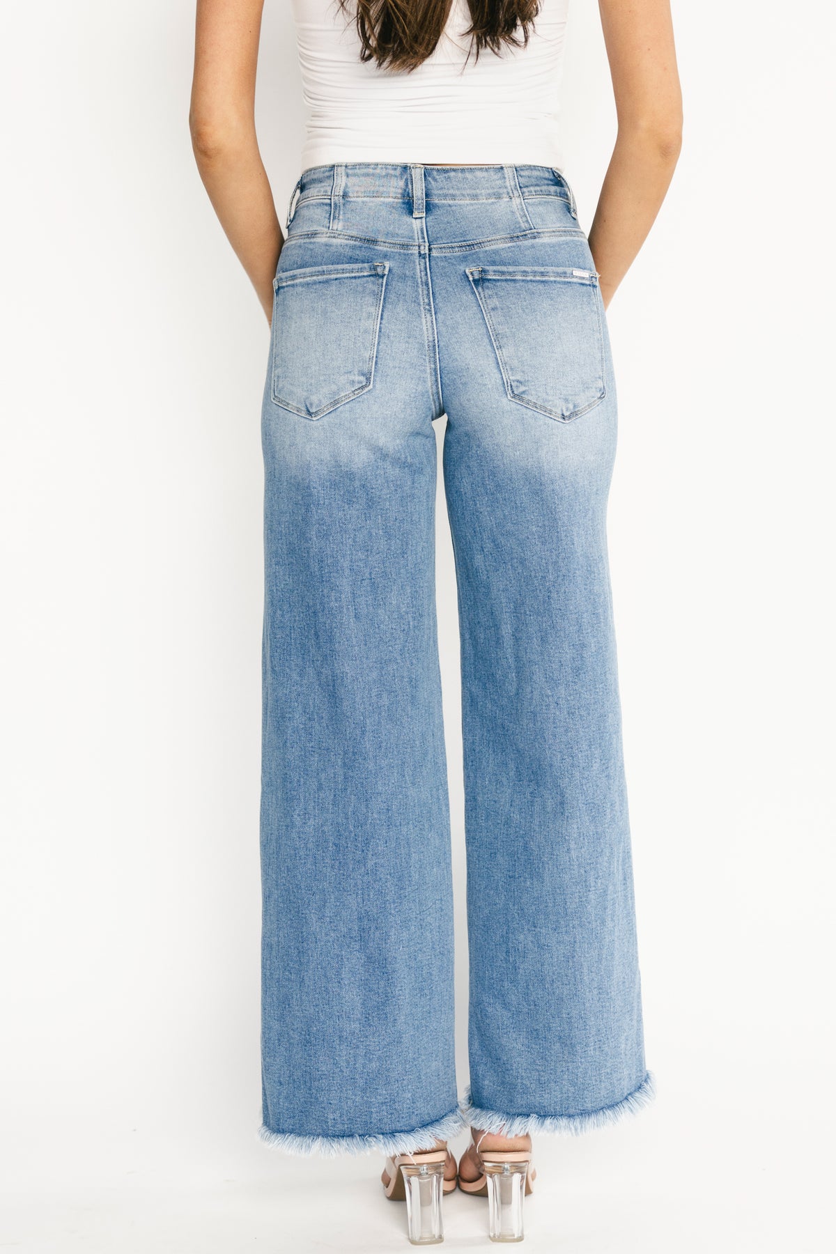 Styled outfit image pairing Jardin high-rise wide-leg jeans with casual top and shoes, showcasing mid-wash versatility and relaxed polish.