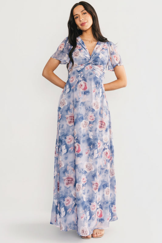 Three-quarter view of the dusty blue floral Promise Maxi Dress highlighting the short flutter sleeves, keyhole back button, and soft chiffon drape.